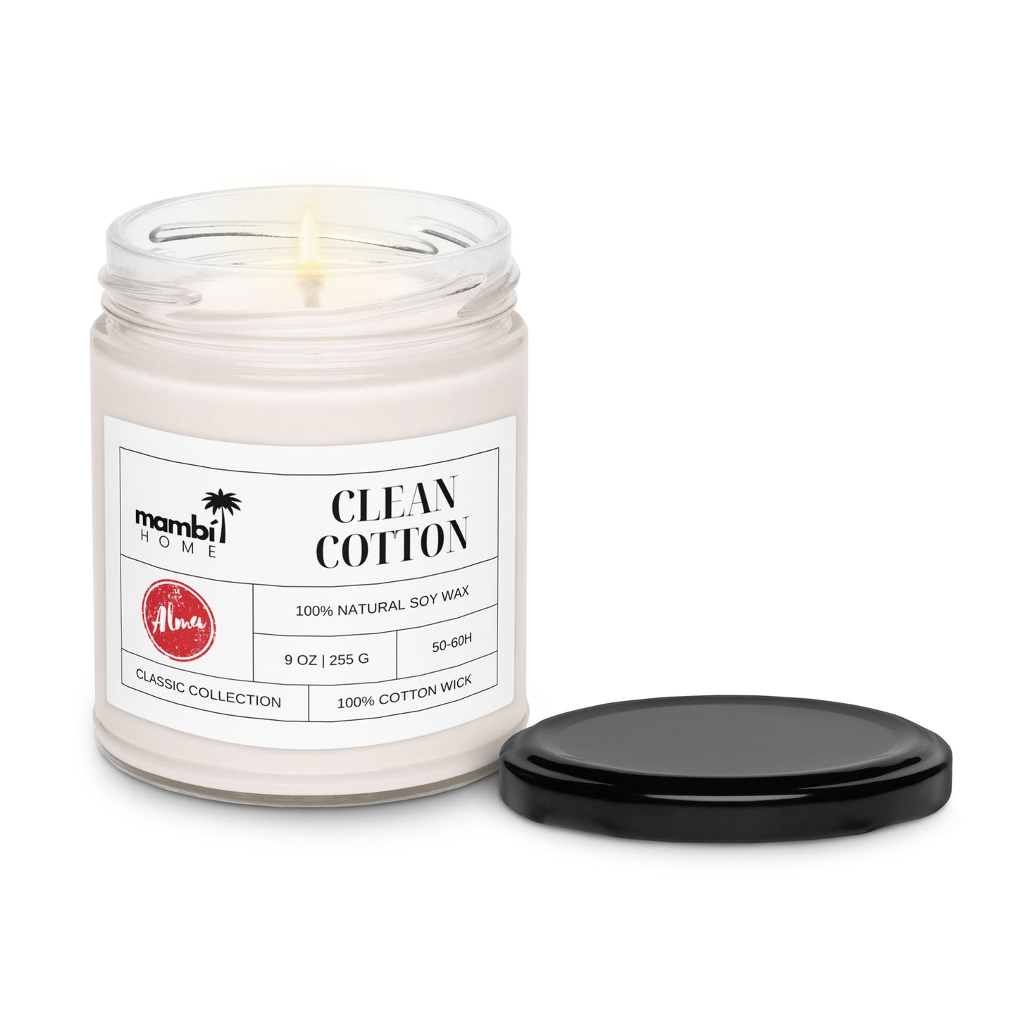 A lit white candle in a glass jar labeled Clean Cotton features 100% natural soy wax and a 100% cotton wick. The eco-friendly candle’s black lid rests beside the jar on a white background.