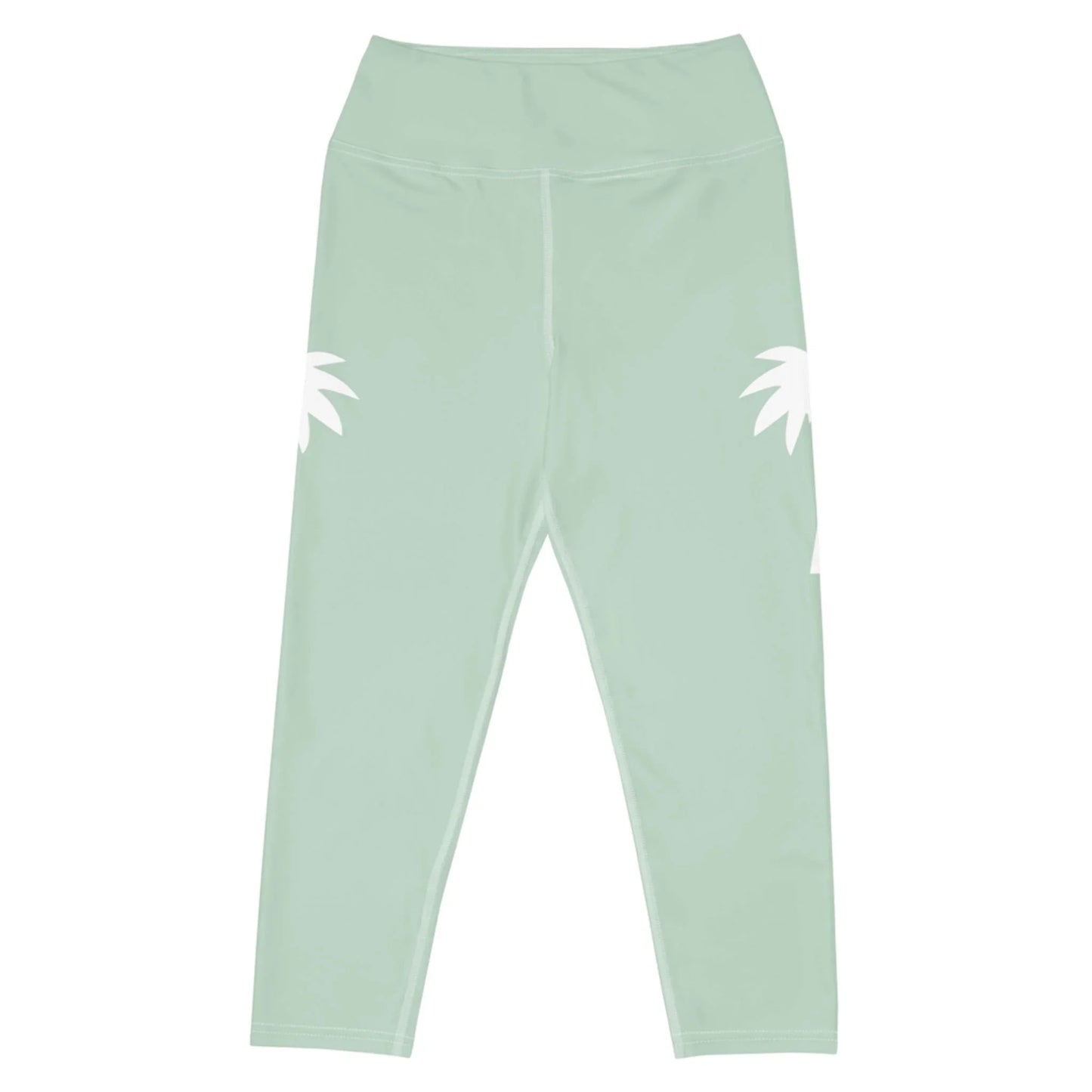 The Aventura High-Rise Yoga Capri Leggings for women by Printful feature light green, four-way stretch fabric, a wide waistband, and two white abstract palm leaf designs on the hips. Shown flat on a white background.