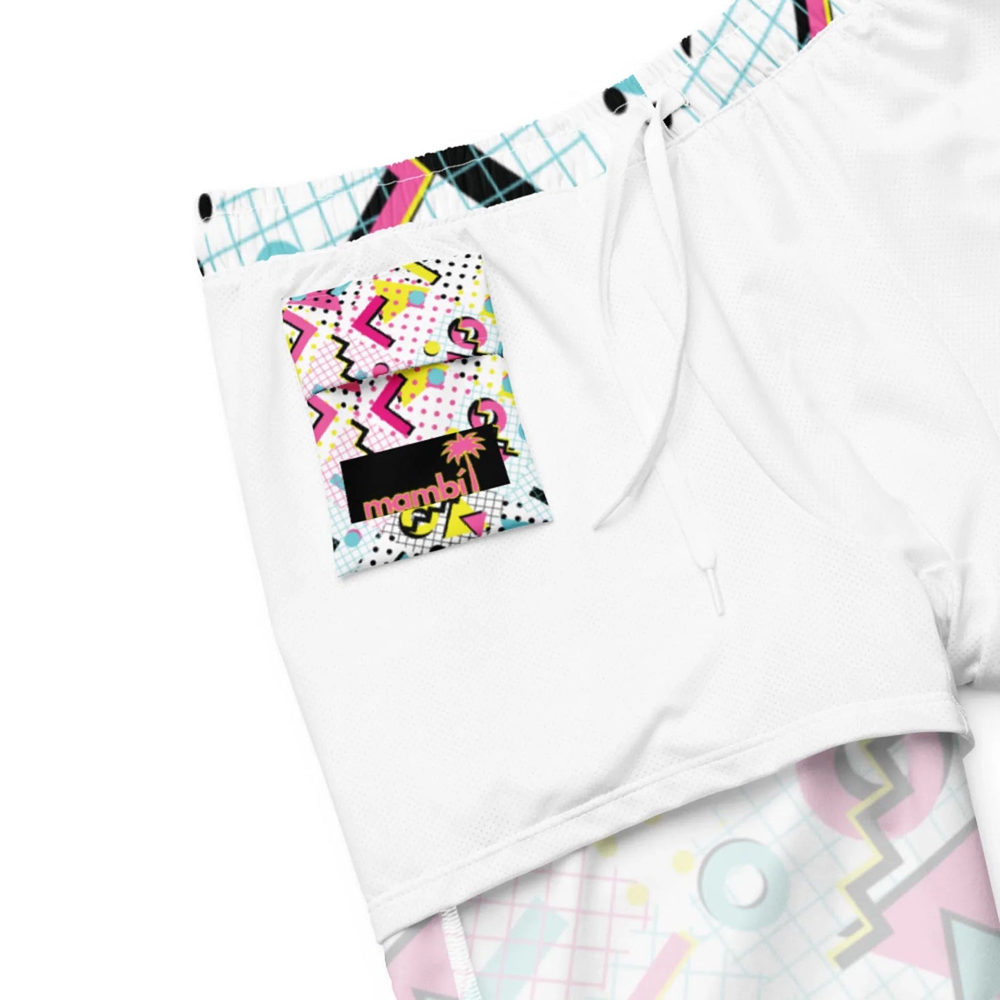 White shorts with a colorful, retro 80s-style patch on the pocket featuring geometric shapes, squiggles, and the Mambí text with a pink palm tree. Finished with a white drawstring and pastel pattern trim for extra flair.