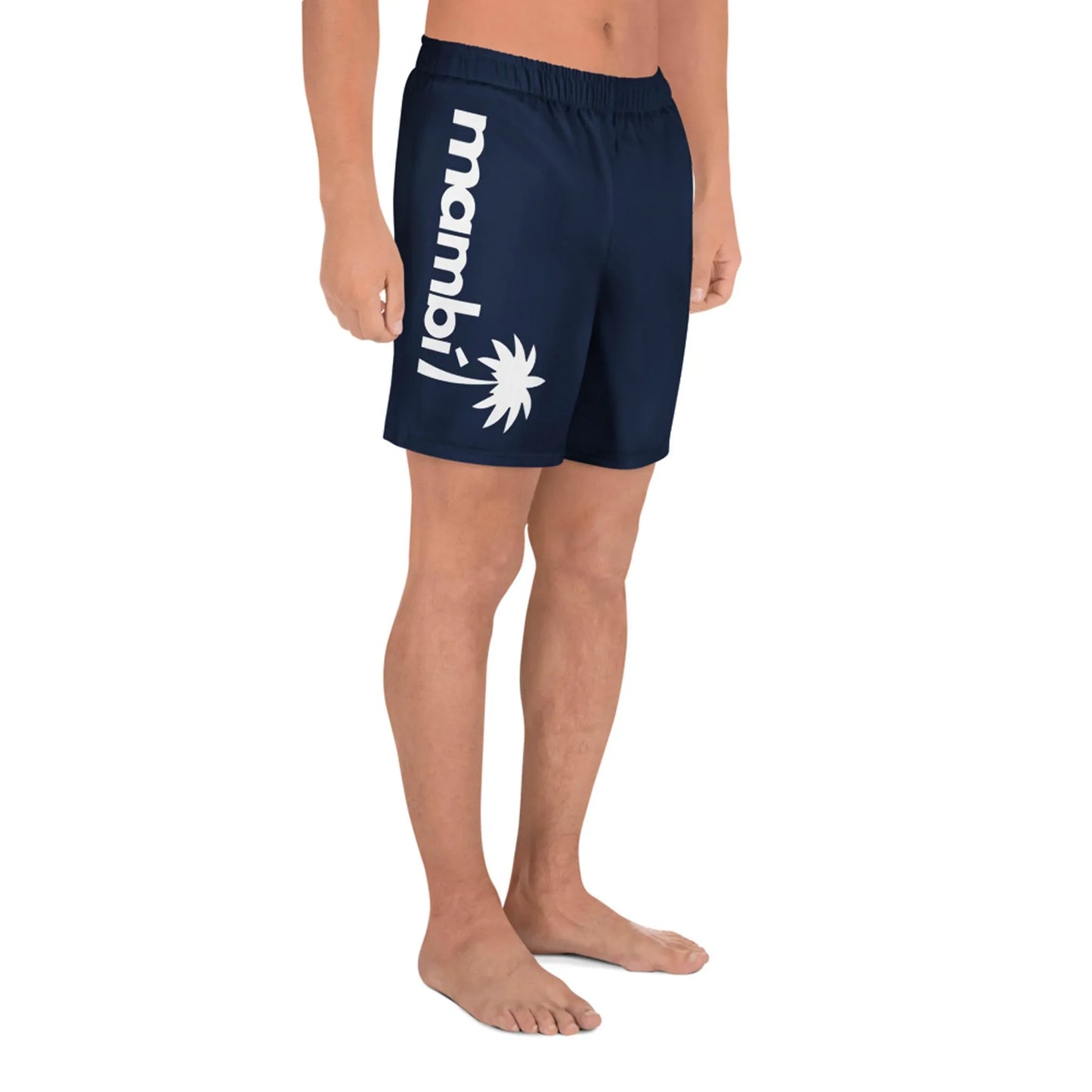 A person stands barefoot wearing Printful Belmar Long Athletic Shorts in navy blue, featuring mambi and a white sunburst graphic on the left leg. The image shows only their legs; head and upper body are not visible.