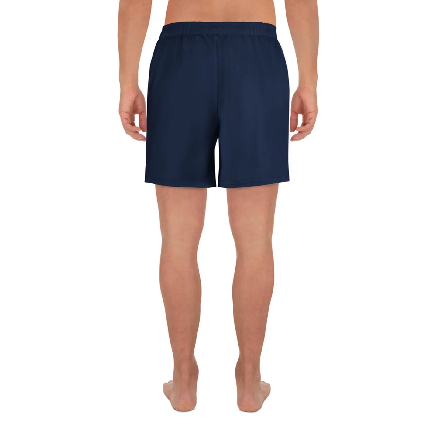 A person stands barefoot facing away in Printful Belmar Long Athletic Shorts | Unisex, navy blue with an elastic waistband for comfort and performance, ideal for running. The background is plain white.