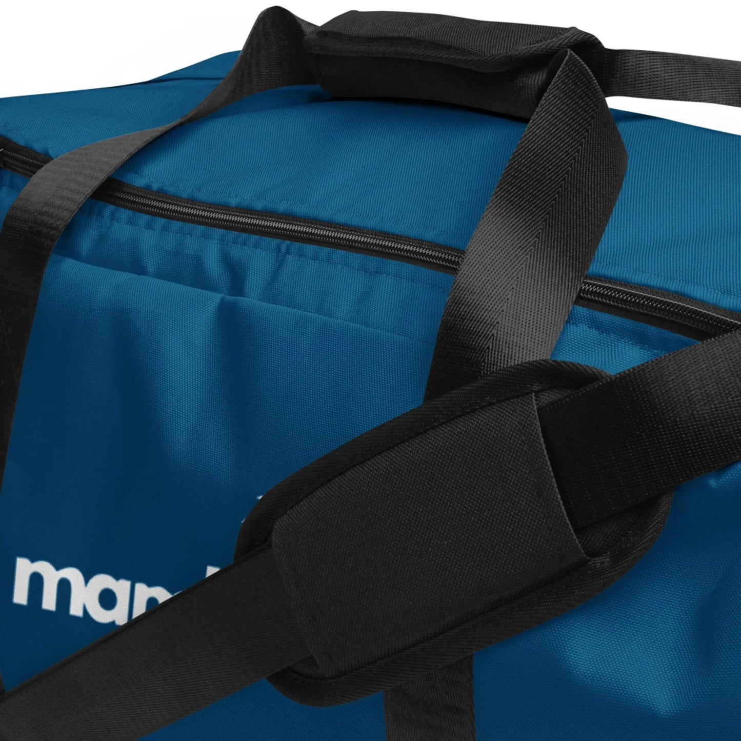 Close-up of a blue Mambí duffel bag with thick black shoulder straps and cushioned pads. The zipper is visible, and part of a white logo appears on the side.
