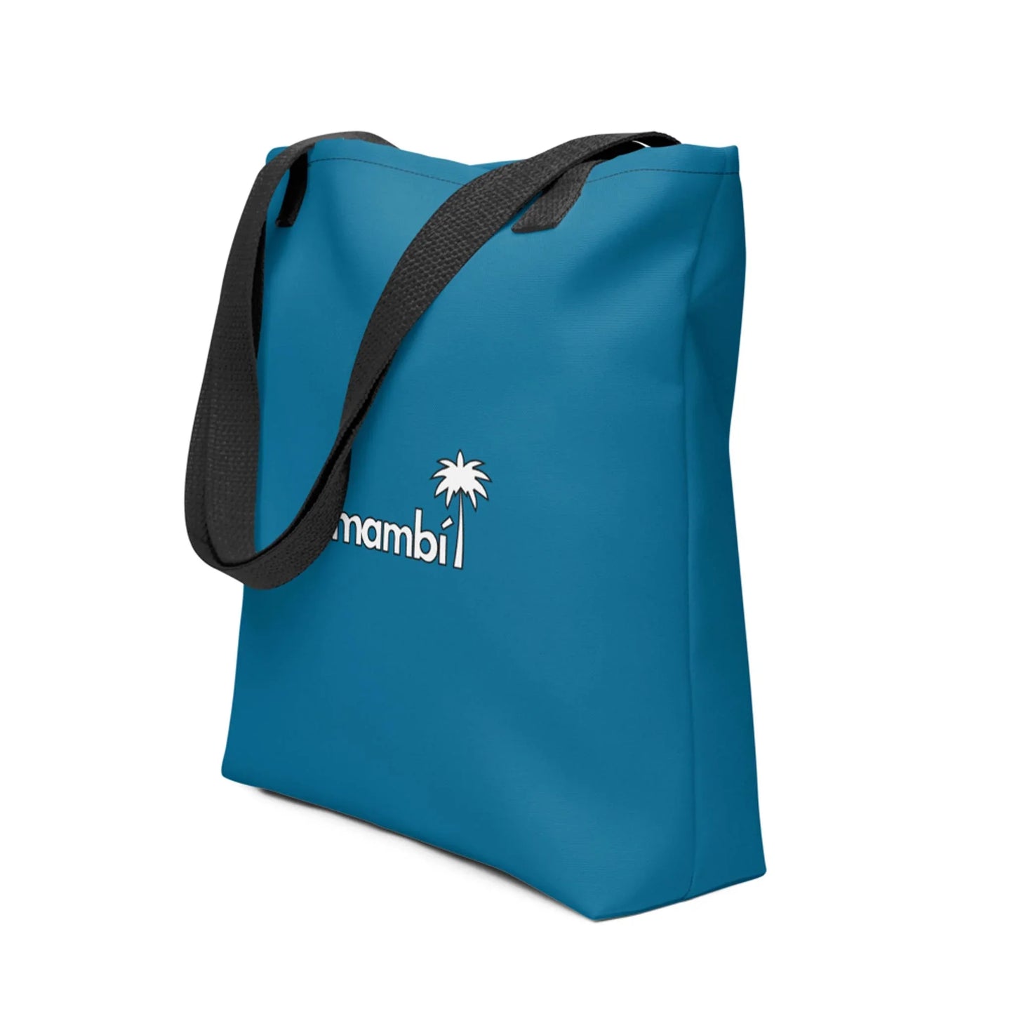A blue tote bag with black shoulder straps features a small white palm tree and the word Mambí printed on the front. The background is plain white.