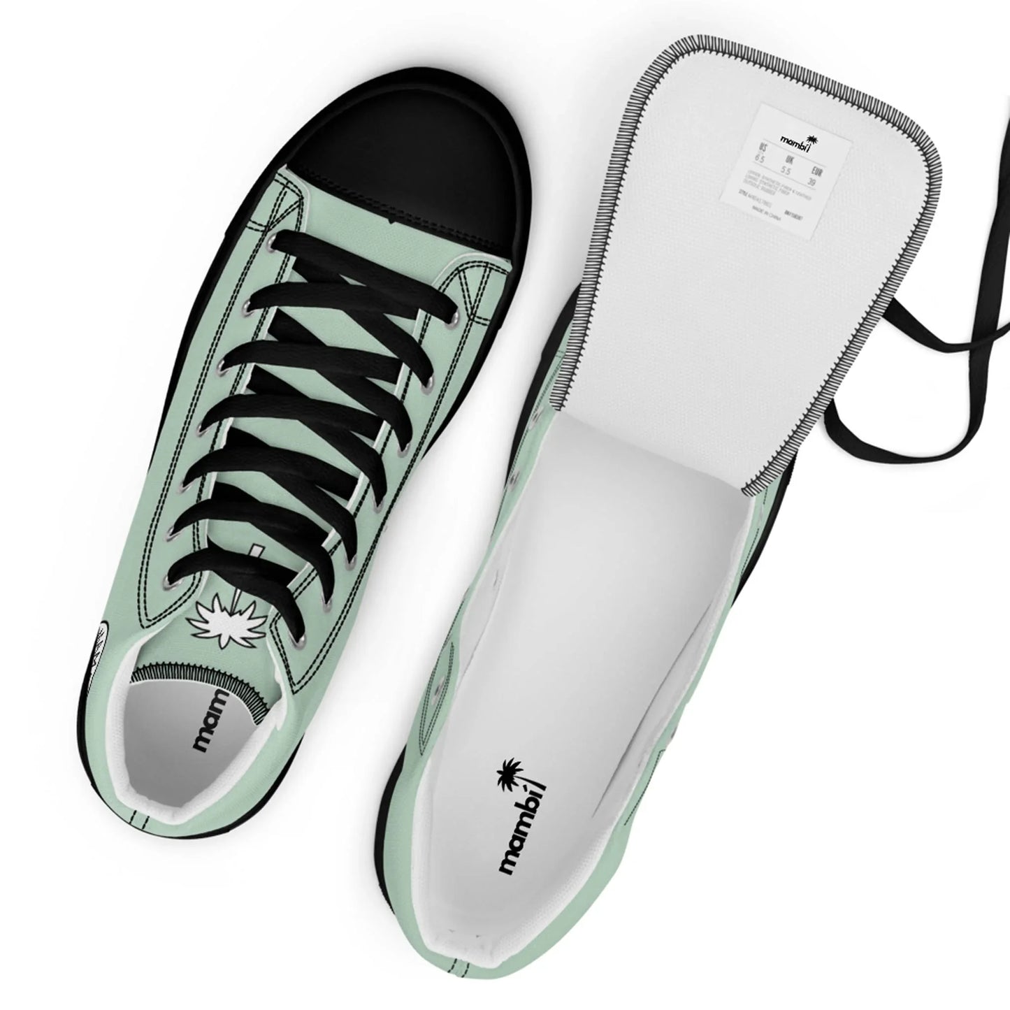 Two mint green Mambí sneakers with black toes and laces. One shoe is upright, showing the top view, while the other is flipped open to reveal the white interior and a visible label.