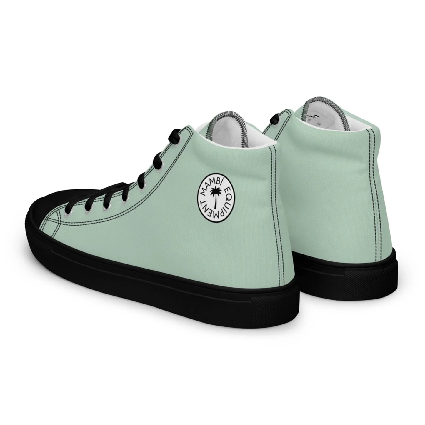 A pair of mint green high-top sneakers with black soles, black laces, and black toe caps. Each shoe features a circular white patch with the words Miami Eco Company, a small palm tree graphic, and subtle Mambí accents.