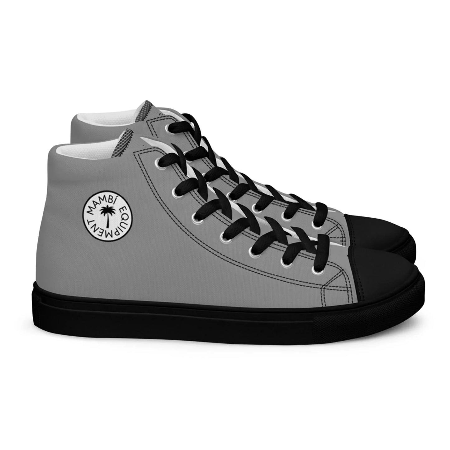 A pair of Mambí high-top sneakers in gray with black soles, black laces, and a round white patch on the side reading MWAMBI EQUALITY EMPOWERMENT with a star symbol in the center.