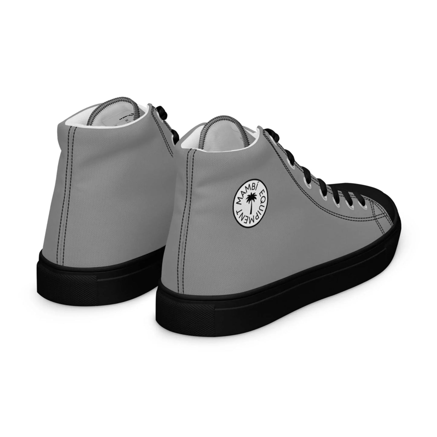 A pair of high-top Mambí sneakers with gray uppers, black laces, and black soles. The side features a circular white logo reading “MAMBI CLUB WEAR” with a small palm tree graphic in the center.
