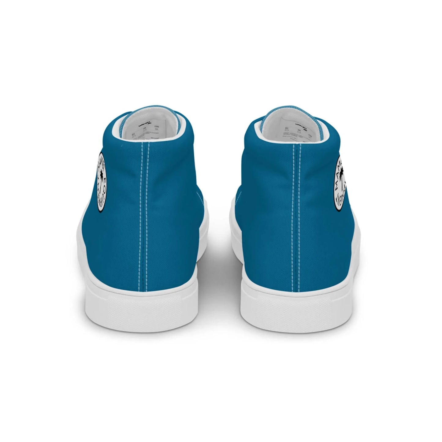A pair of blue high-top Mambí sneakers viewed from the back, featuring white soles and a small circular black and white logo near the heels.