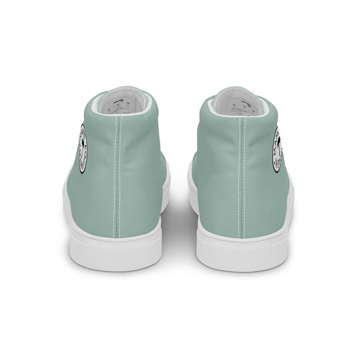 A pair of light teal Mambí high-top sneakers viewed from the back. Each shoe has a white sole and features a small circular black and white graphic on the outer side near the heel.