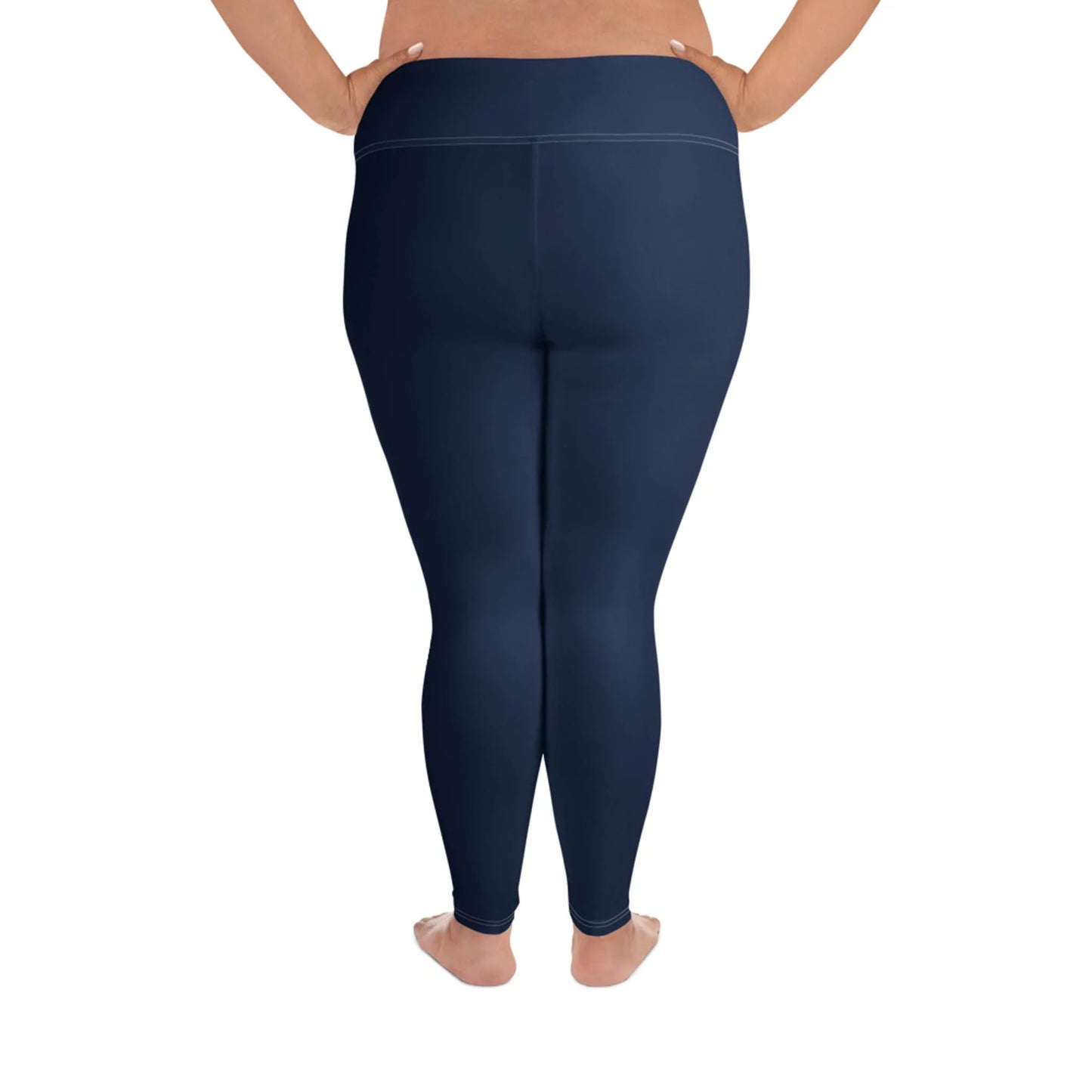 A person standing barefoot shown from the back, wearing high-waisted, navy blue Mambí leggings. The background is white.
