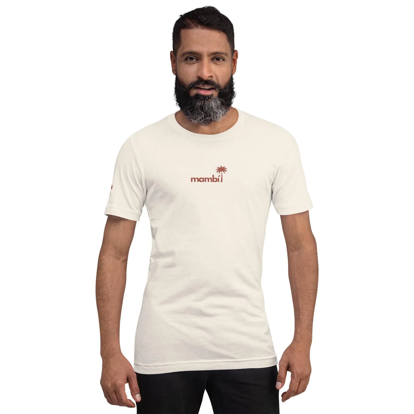A man with dark hair and a beard stands facing forward, wearing a white t-shirt featuring the word Mambí and a small red palm tree graphic on the chest. The background is plain white.
