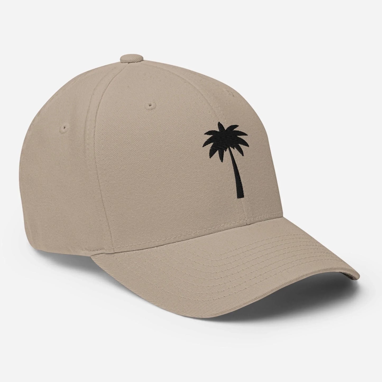 A beige Mambí baseball cap with a curved brim, featuring a small black palm tree graphic on the front left panel. The cap is displayed on a plain white background.