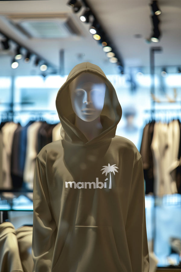 Mannequin wearing a beige hoodie with 'mambi' logo in a store setting