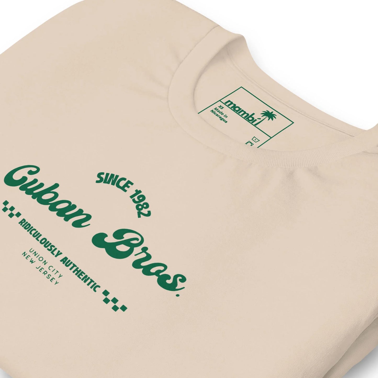The Printful Cuban Bros Graphic Tee | Unisex features beige fabric, green text with “Since 1982” and “Union City, New Jersey,” and a palm tree logo—ideal for entrepreneurs who appreciate standout Neighborhood Collection designs.