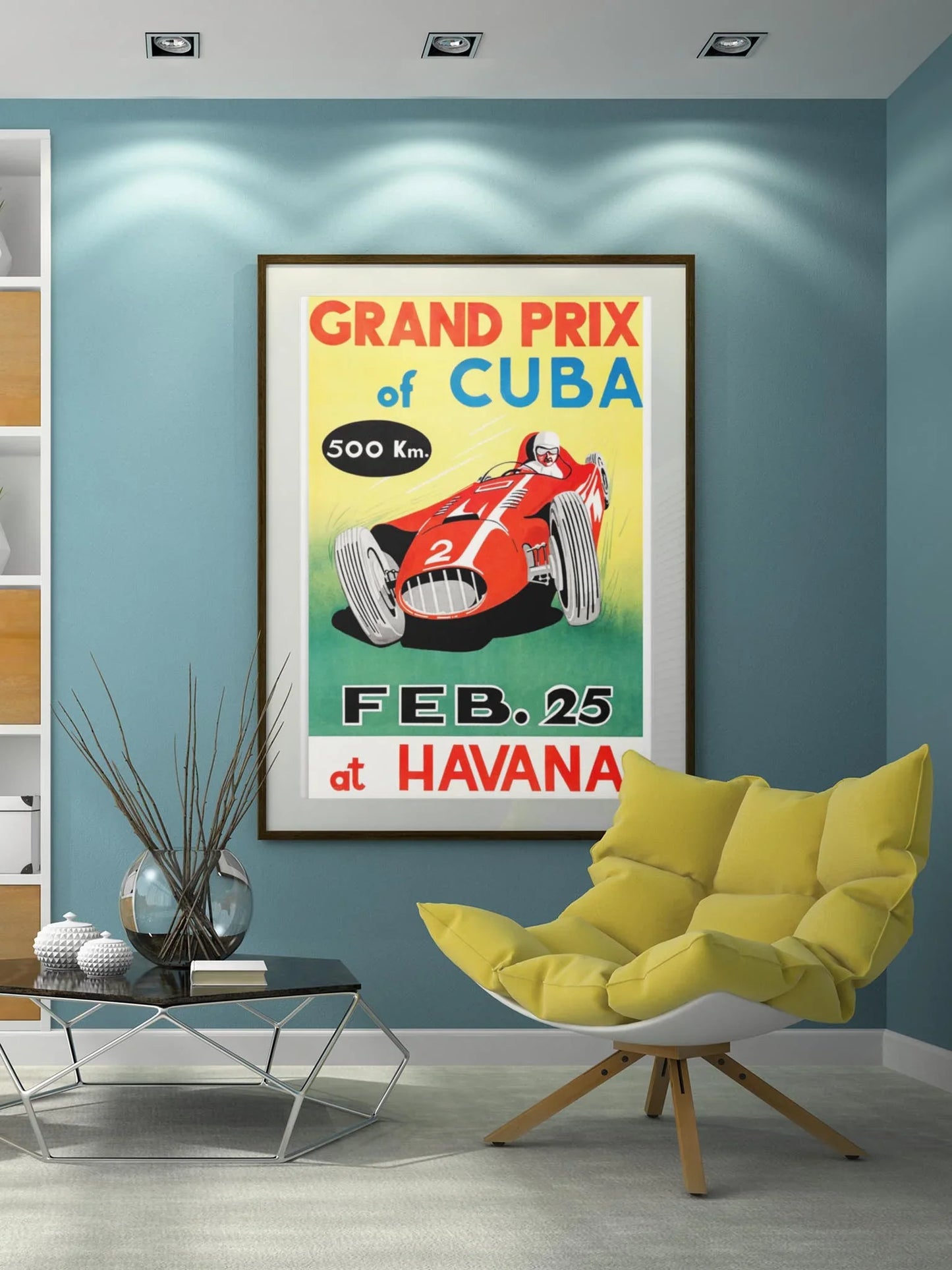 A modern living room with blue walls displays Printful’s Cuban Grand Prix reprinted vintage poster (24x36, premium luster paper) above a geometric glass coffee table and a yellow lounge chair.
