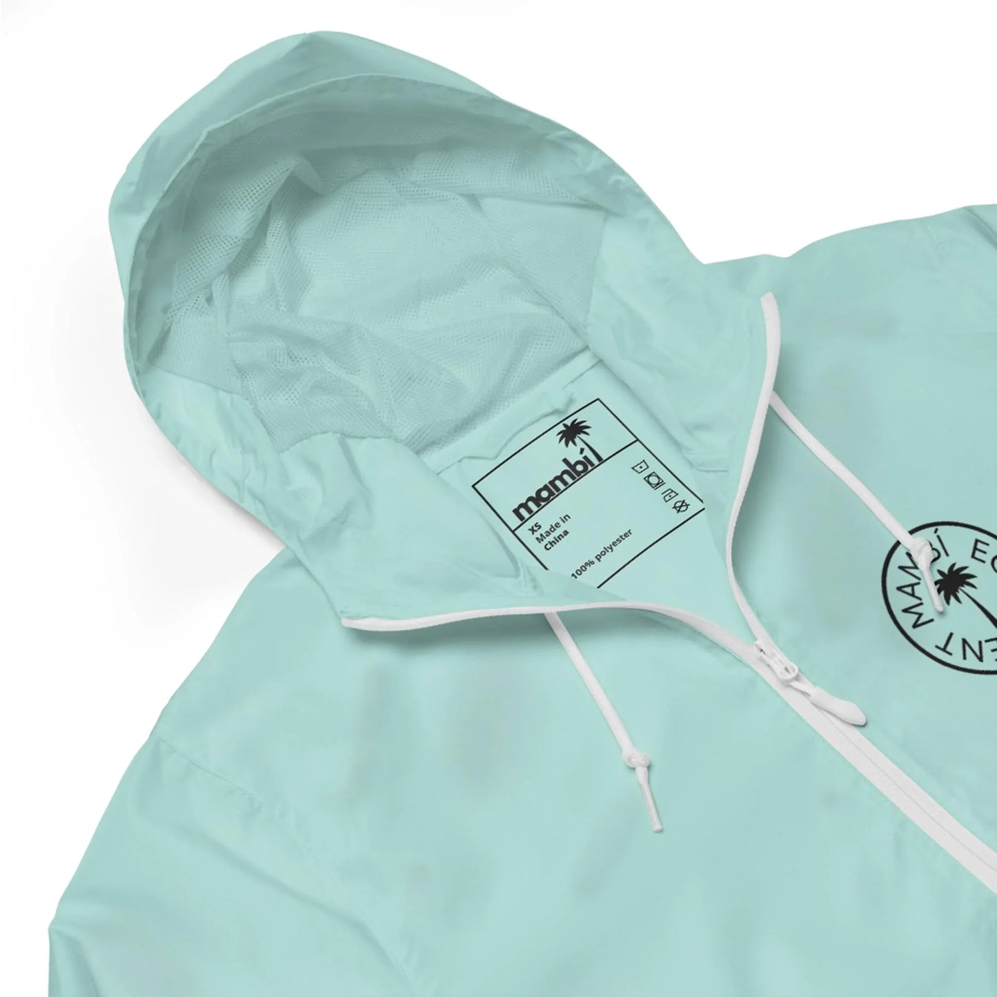 Light blue Mambí hooded jacket with white drawstrings, a white zipper, and a black label inside. The jacket features a circular black logo with a palm tree and text on the chest.
