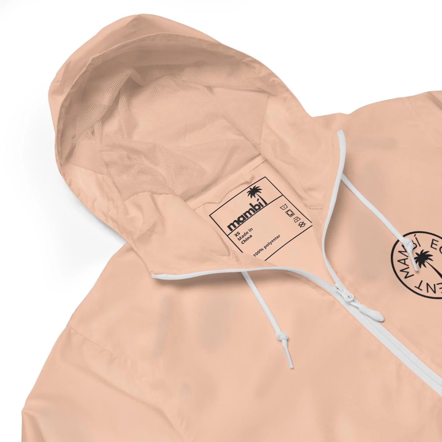 A light pink Mambí hooded windbreaker with a white zipper and drawstrings. The jacket features a circular black logo on the chest and a visible inner label with branding and care details.
