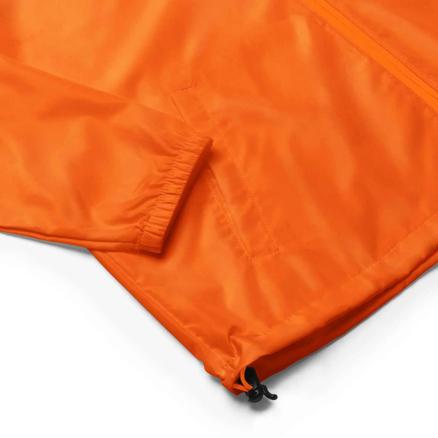 Close-up of a Mambí orange jacket featuring a sleeve, zippered front, pocket, and an adjustable drawstring at the hem. The fabric has a slight sheen.
