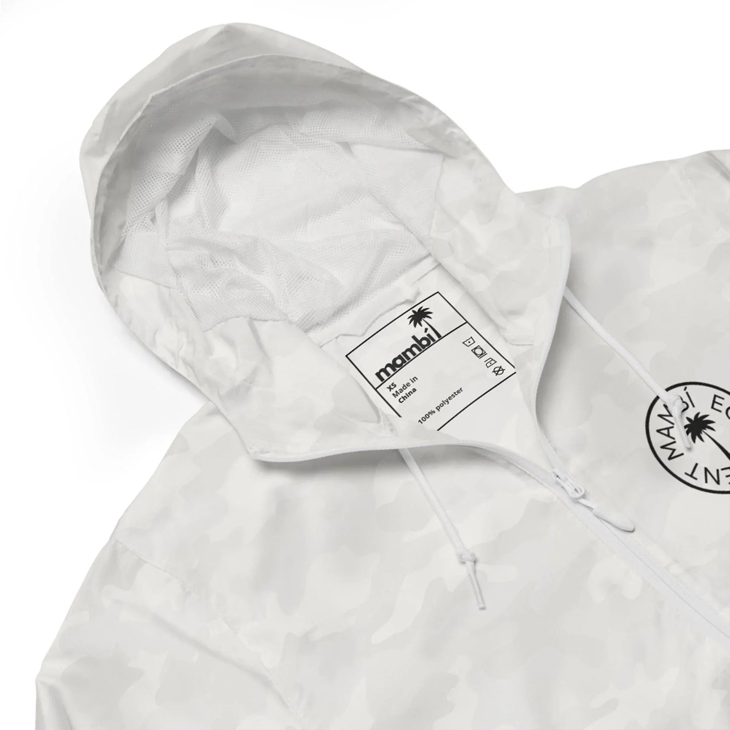 A close-up of a white camo-patterned hooded jacket featuring a black circular logo on the chest and an inner label displaying the brand name Mambí and size details.