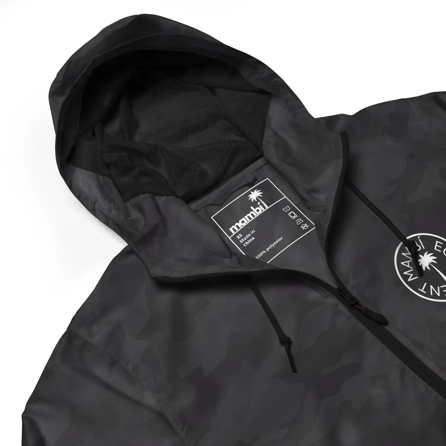A black camo hooded jacket with mesh lining, drawstrings, and a white manahi label inside the collar. A circular palm tree logo with the text Manahi Equipment and subtle Mambí details appears on the chest.