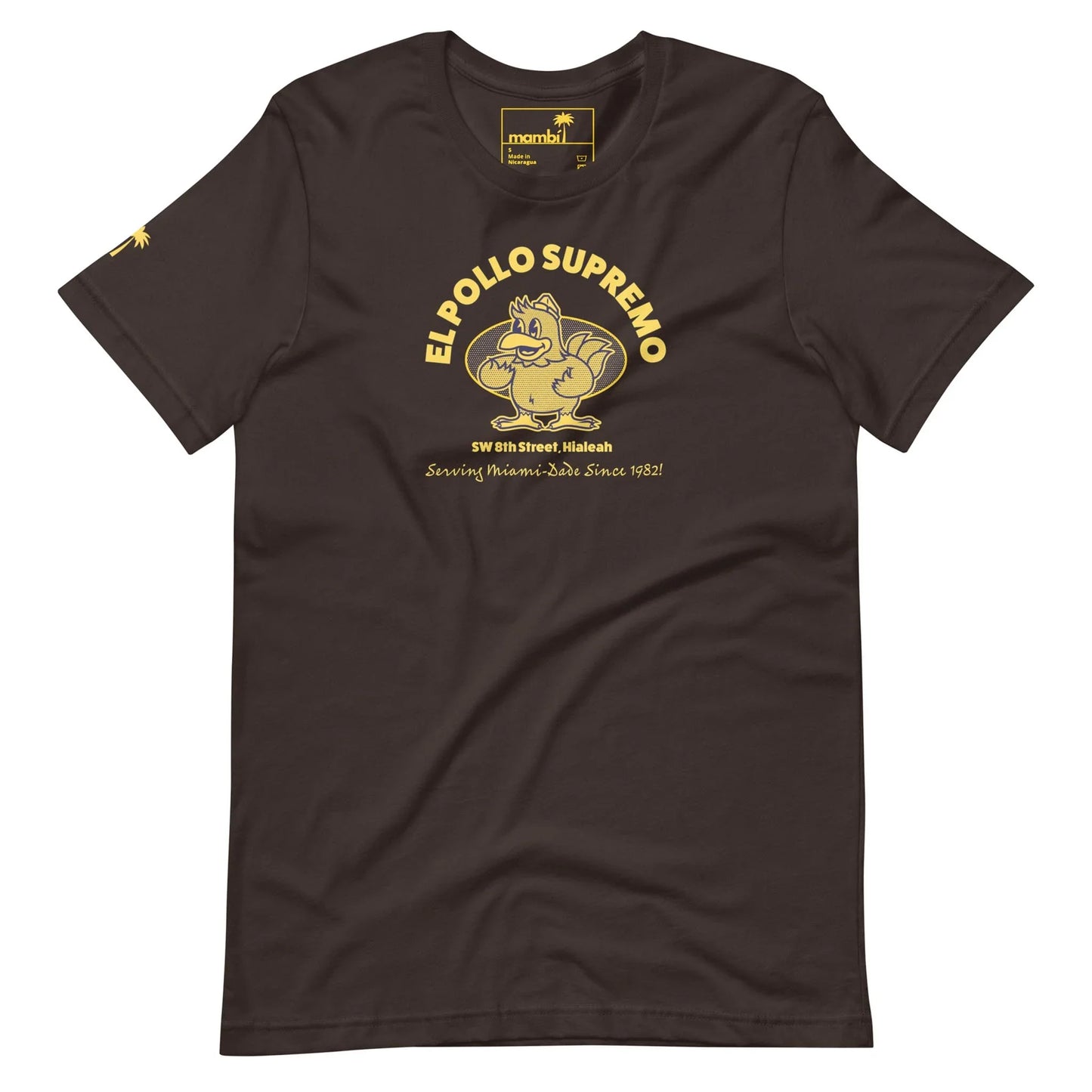 Brown t-shirt featuring a cartoon chicken flexing its muscle, with the text EL POLLO SUPREMO above and SW 8th Street, Hialeah. Proudly celebrating Mambí roots since 1982 in bold yellow below.