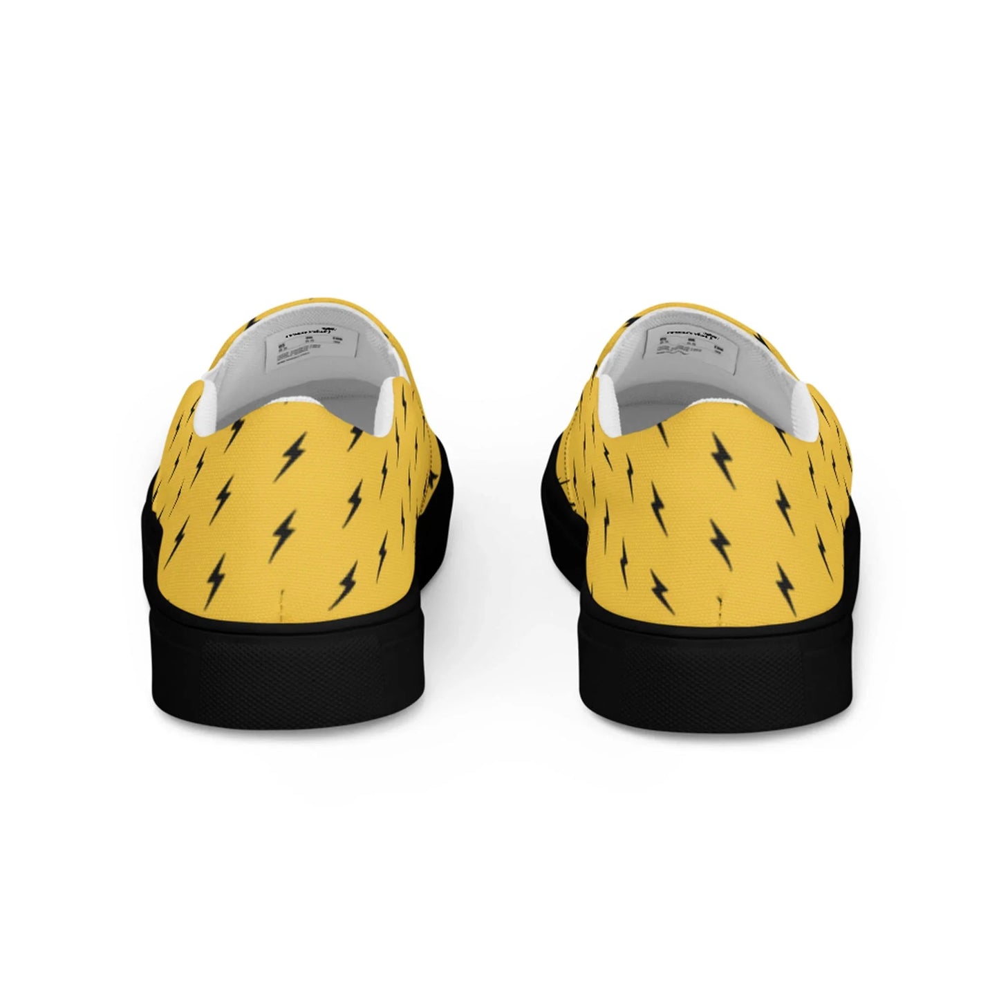The Electra Handmade Slip-On Canvas Shoes by Printful feature a bold yellow canvas with black lightning bolt pattern, black soles, and are shown from the back—perfect for making a striking fashion statement.