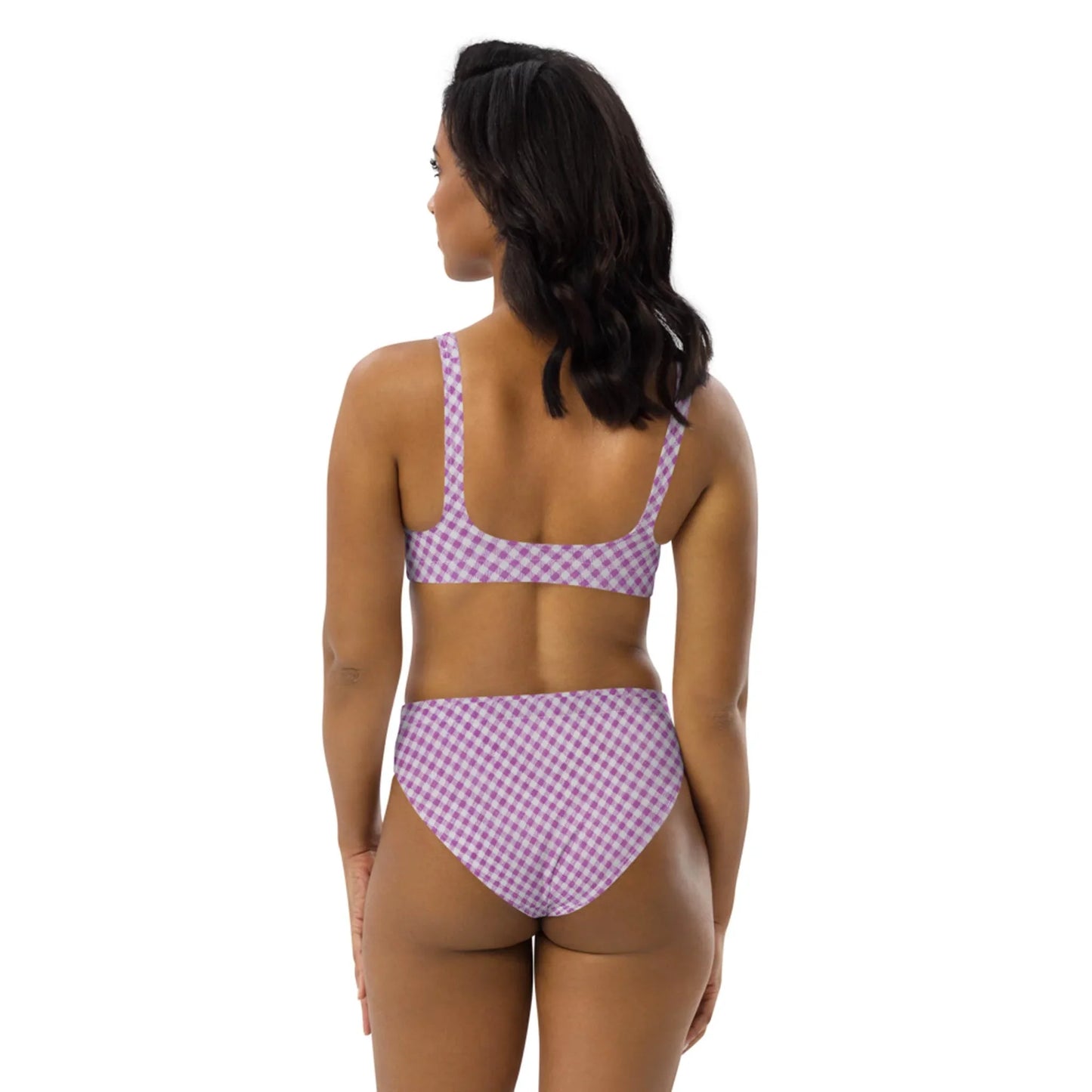 A woman stands facing away, wearing a purple and white checkered Mambí bikini against a plain white background.