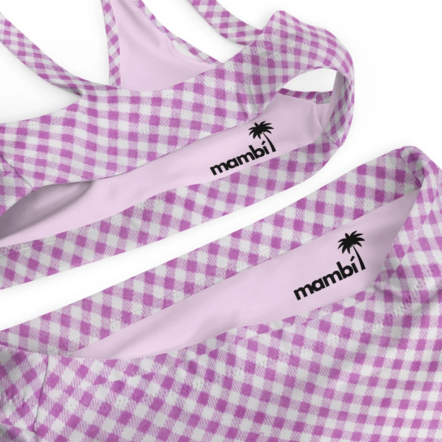 Close-up of a swimsuit with a lavender and white gingham pattern. The light pink inner lining features the word Mambí alongside a palm tree logo printed in black.