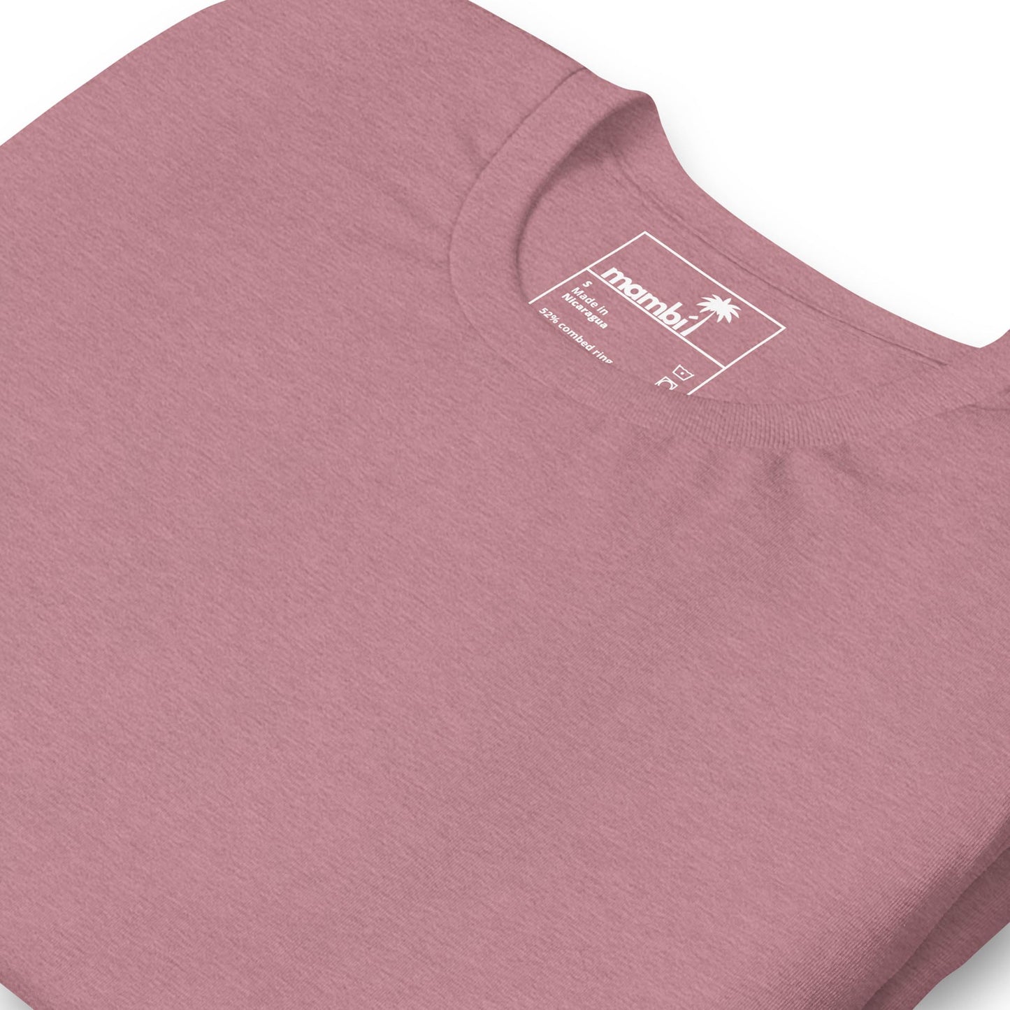A close-up of a mauve-colored crew neck T-shirt, folded neatly to display the neckline and inside label with Mambí branding and a small palm tree icon.