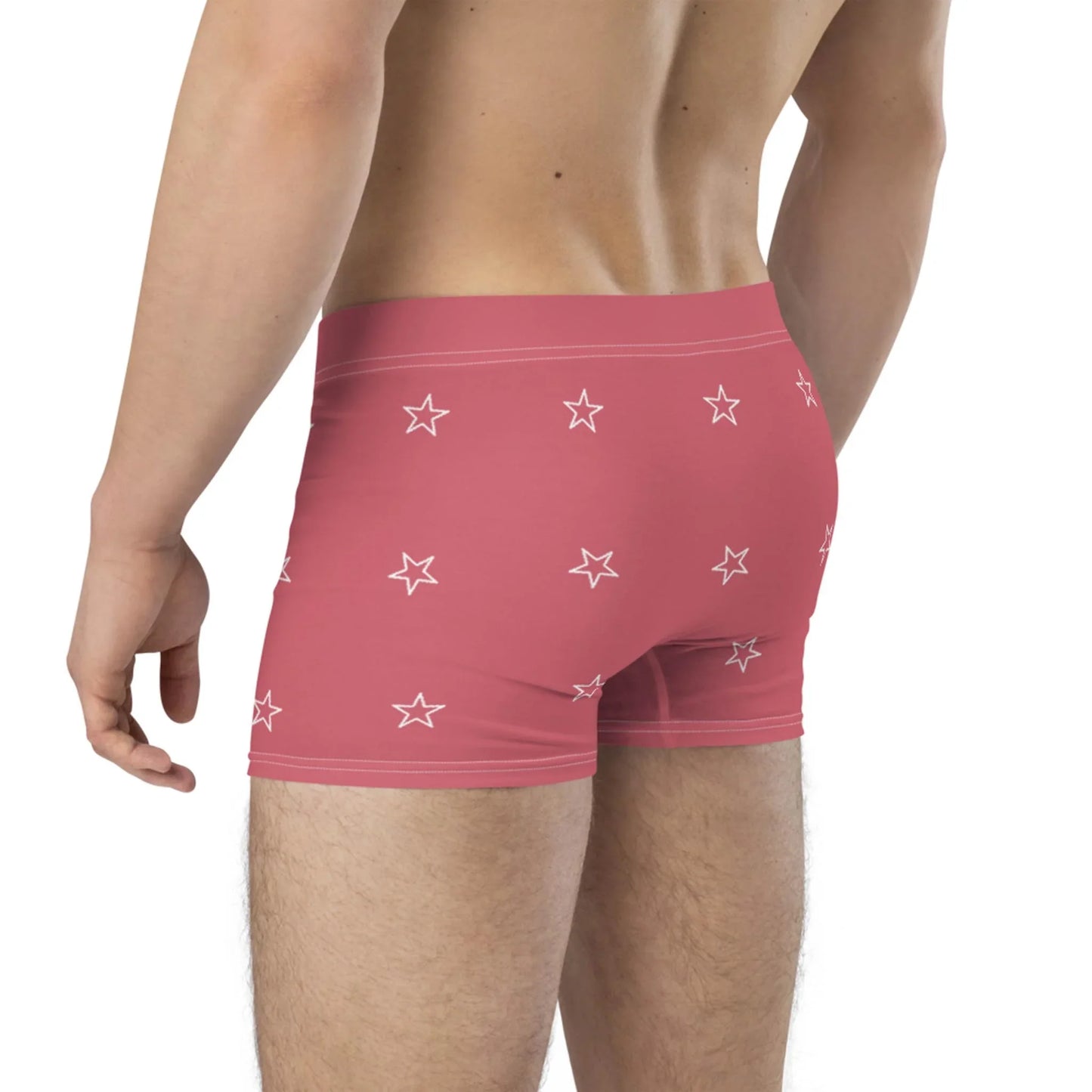 A person wearing pink Mambí boxer briefs with a white star pattern is shown from the back, with their upper back, waist, and upper legs visible.