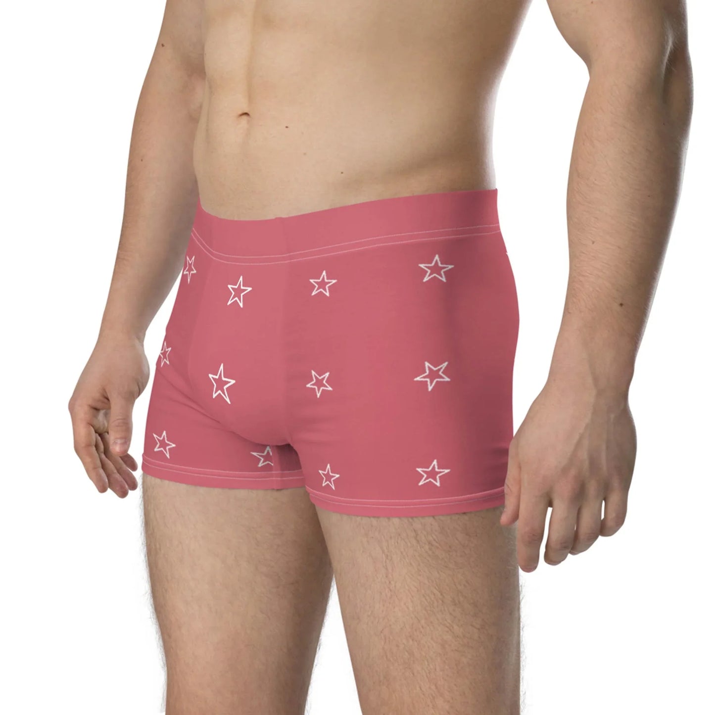 A man wearing Mambí pink boxer briefs with white star patterns, standing against a white background, shown from mid-chest to mid-thigh.
