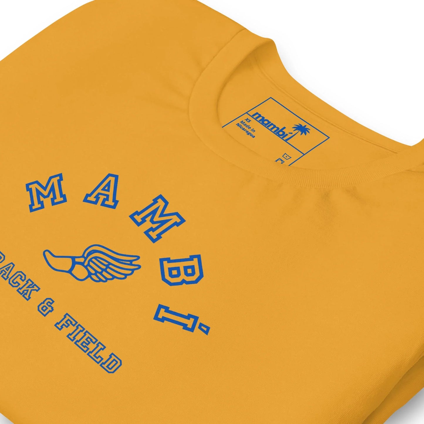 A close-up of the Falcon Varsity Track & Field Tee from Printful, mustard yellow with royal blue “MAMBI TRACK & FIELD” text and a winged shoe graphic. The inner tag also features the Printful brand name.