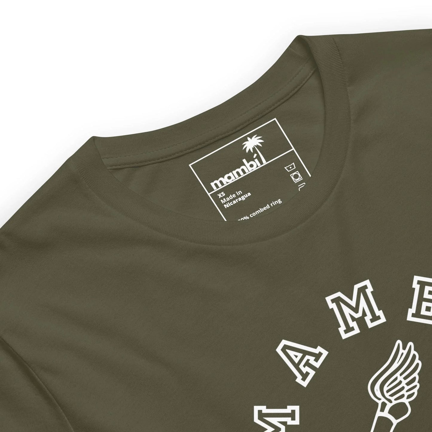 Close-up of an olive green Mambí t-shirt with a white printed neck label showing the size, brand, and care instructions. Bold white letters from a graphic design are visible on the front.
