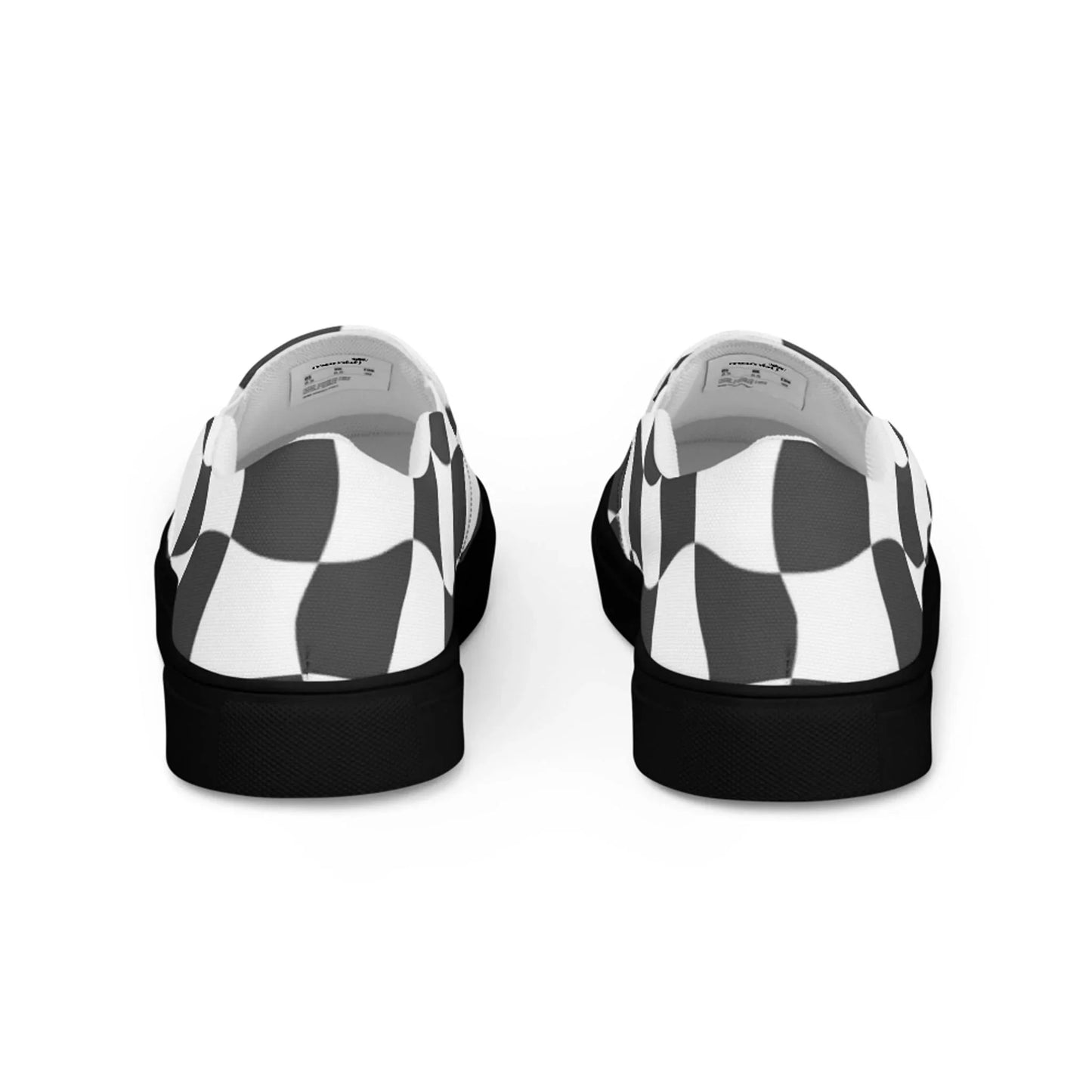 A pair of Mambí slip-on shoes with a black-and-white checkered pattern, viewed from the back and displaying the heels, inner lining, and black soles.