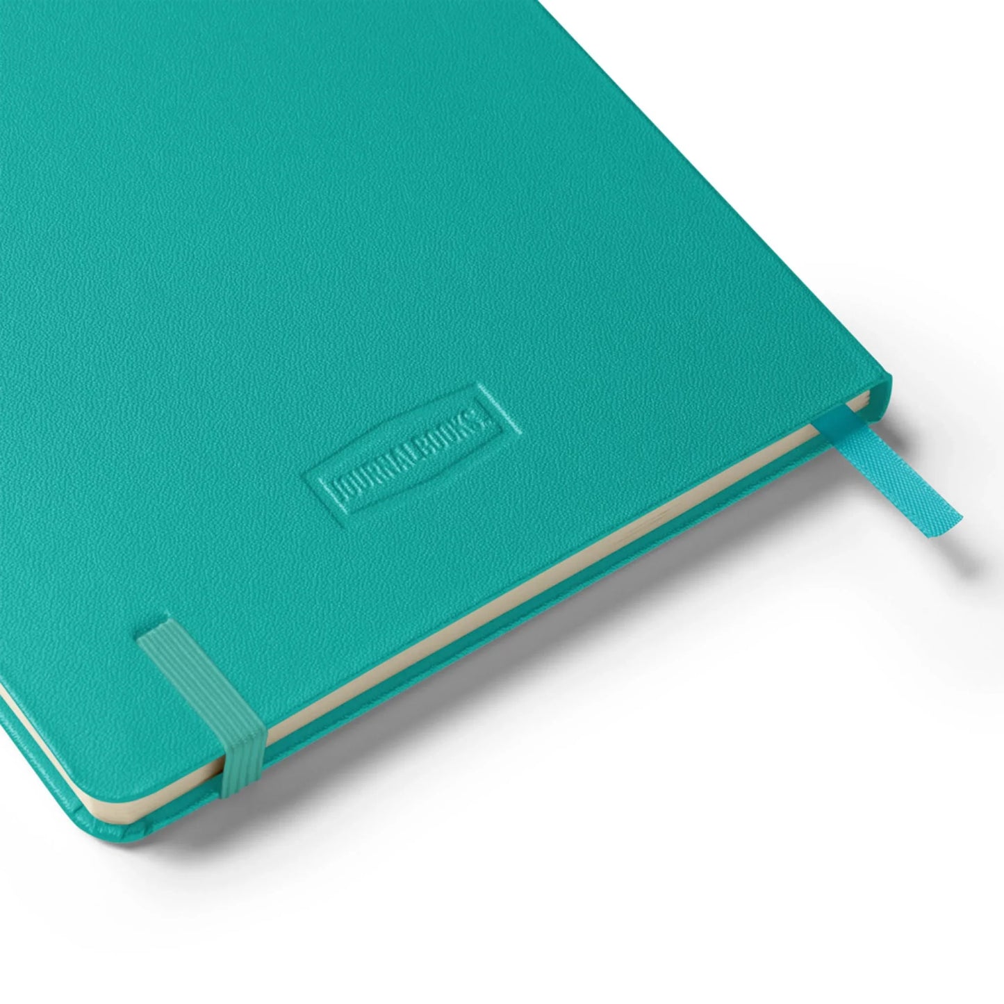 A turquoise Mambí hardcover journal with an elastic band, ribbon bookmark, and JOURNAL BOOKS embossed on the cover, shown on a white background.