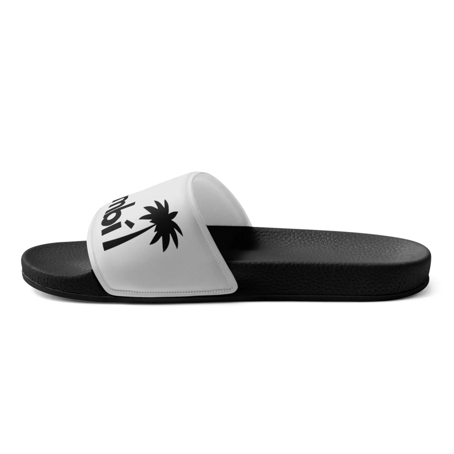 A black slide sandal with a white strap featuring a black palm tree graphic, partial text, and Mambí-inspired style. The sandal has a textured sole and a simple, casual design.