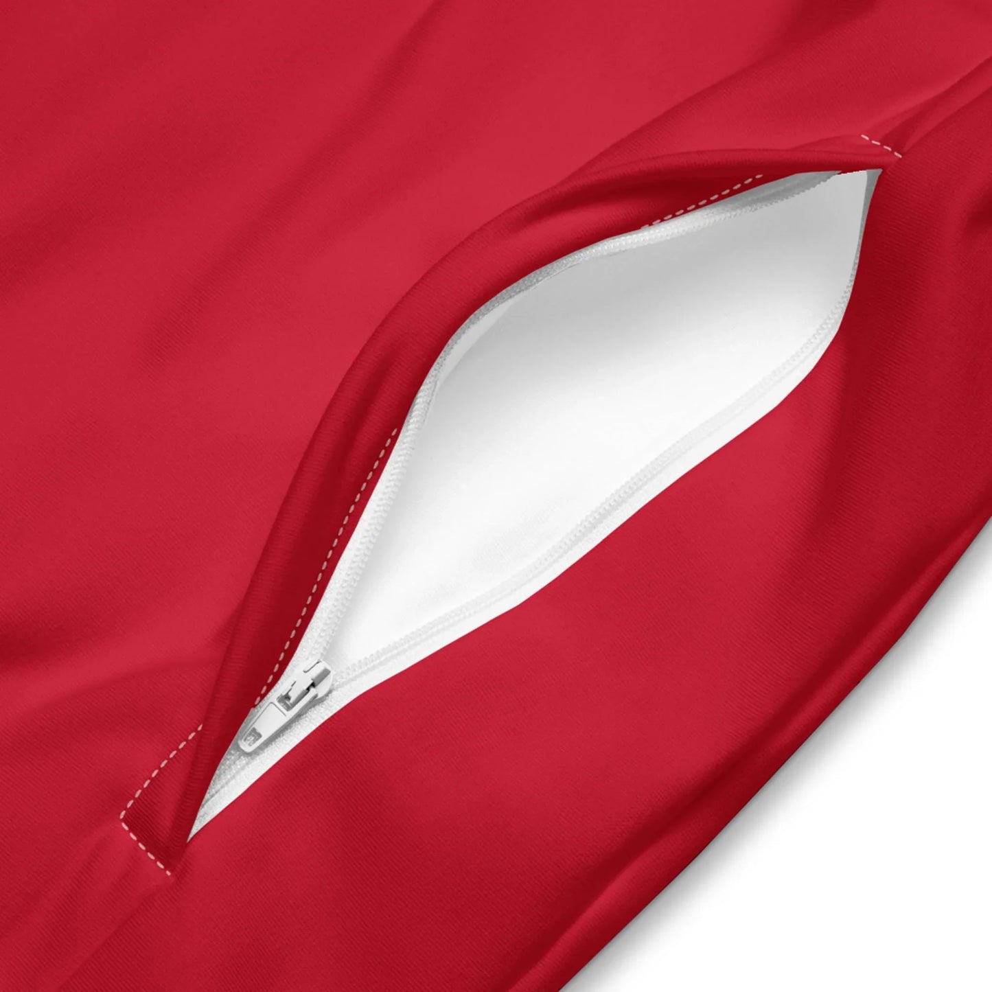 Close-up of a red Mambí fabric garment featuring a white zippered pocket, slightly open to reveal the white interior lining.