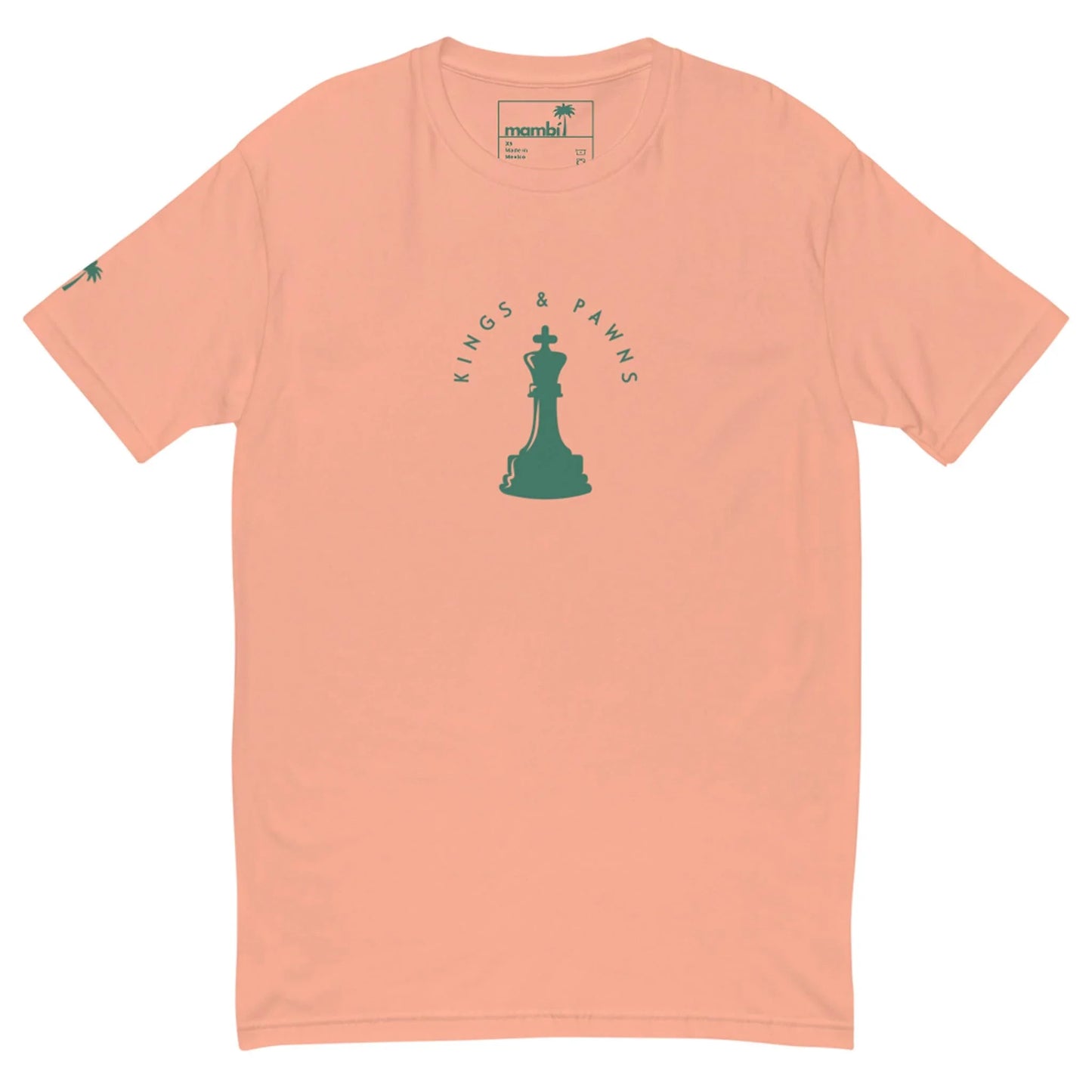 Peach-colored Mambí t-shirt featuring a green chess king piece at the center, with KINGS & PAWNS in a semicircle above and below. A small green palm tree decorates the left sleeve.