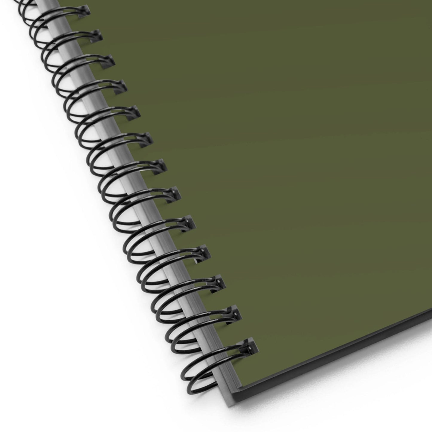 Close-up of the corner of a custom wire-bound notebook with a dark green cover, showing the black metal binding and part of the pages beneath.