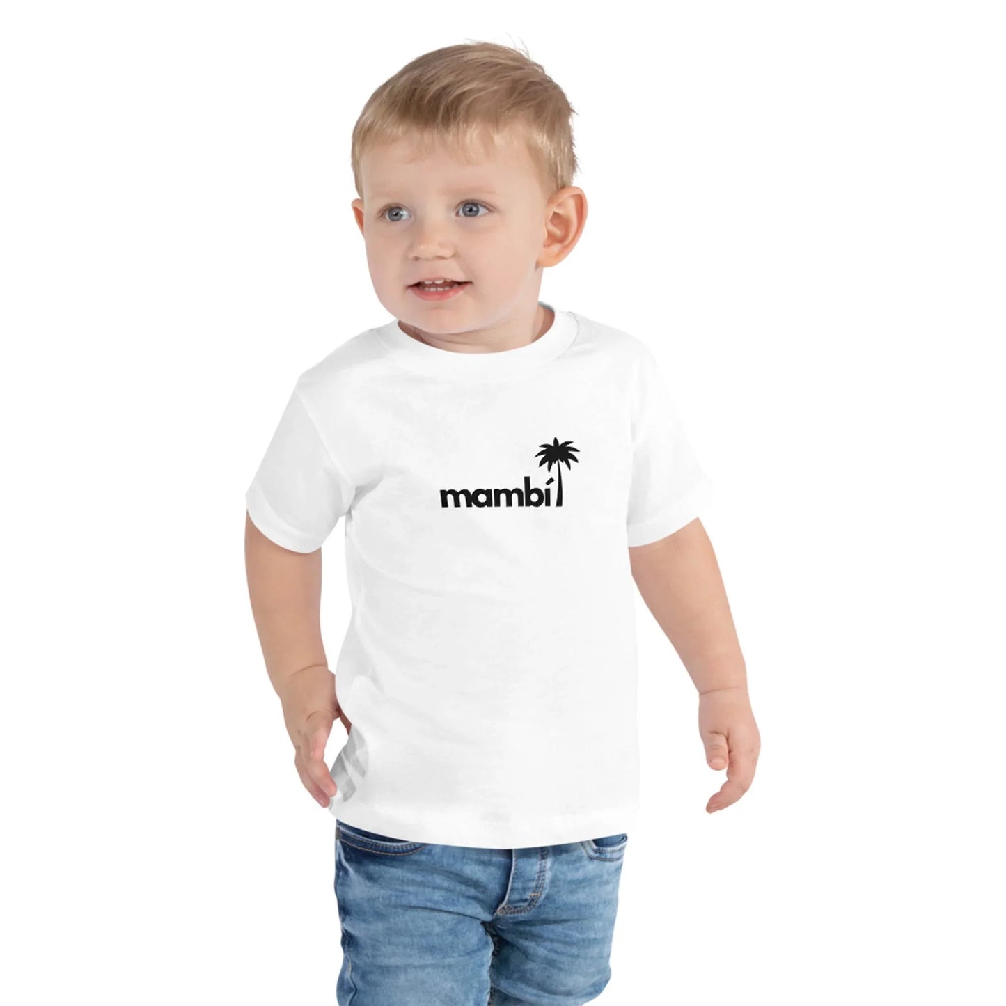 A young child with short blond hair wears a white t-shirt featuring the word Mambí and a small palm tree graphic in black, paired with blue jeans, standing against a plain white background.