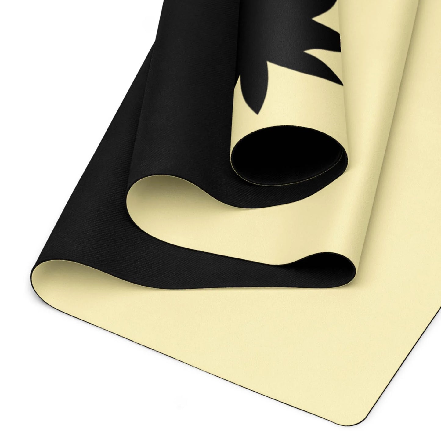 A close-up of a rolled Mambí yoga mat with a black and cream-colored design, featuring a partial silhouette of a leaf or plant shape.