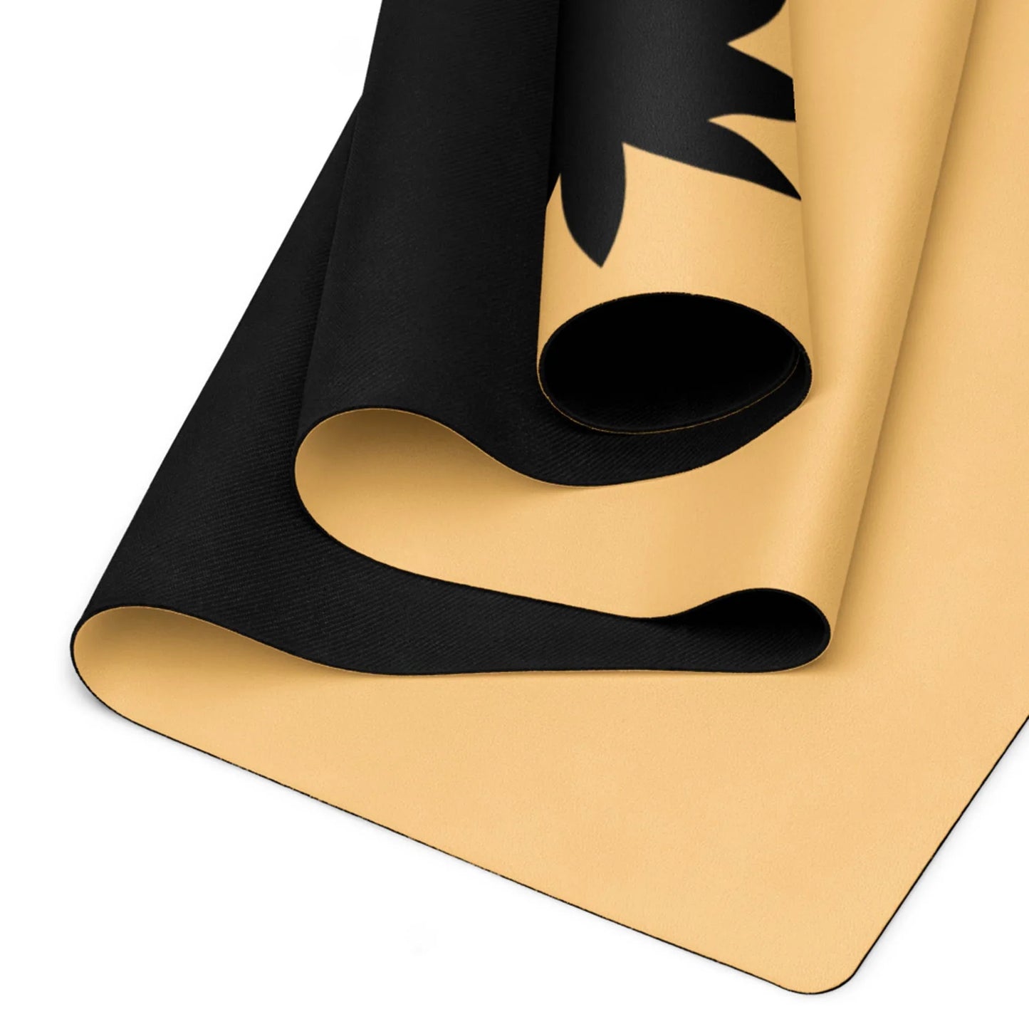 A close-up of a rolled Mambí yoga mat with a beige underside and black top, partially revealing a black abstract or floral design on the upper surface.