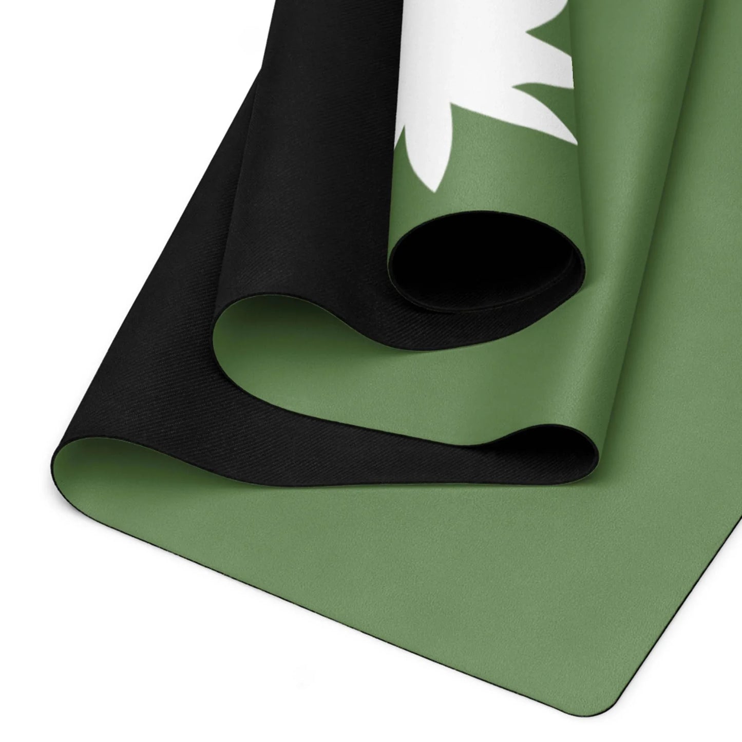 A close-up of a rolled green and black Mambí yoga mat with a white abstract design on one corner, highlighting the layers and texture of the material.