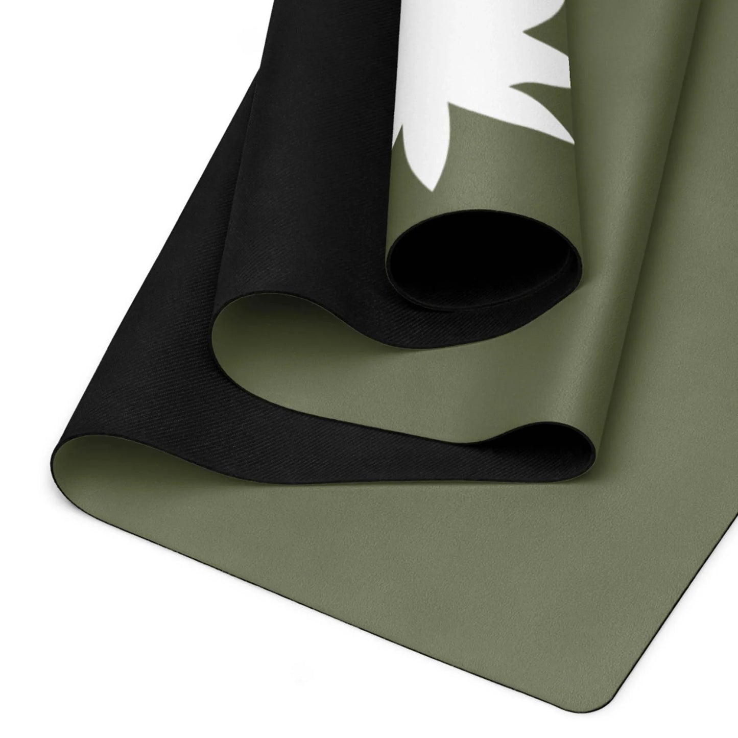 A close-up of a rolled, two-tone Mambí yoga mat with an olive green top layer featuring a white leaf design and a black underside. The edges and texture of the mat are clearly visible.