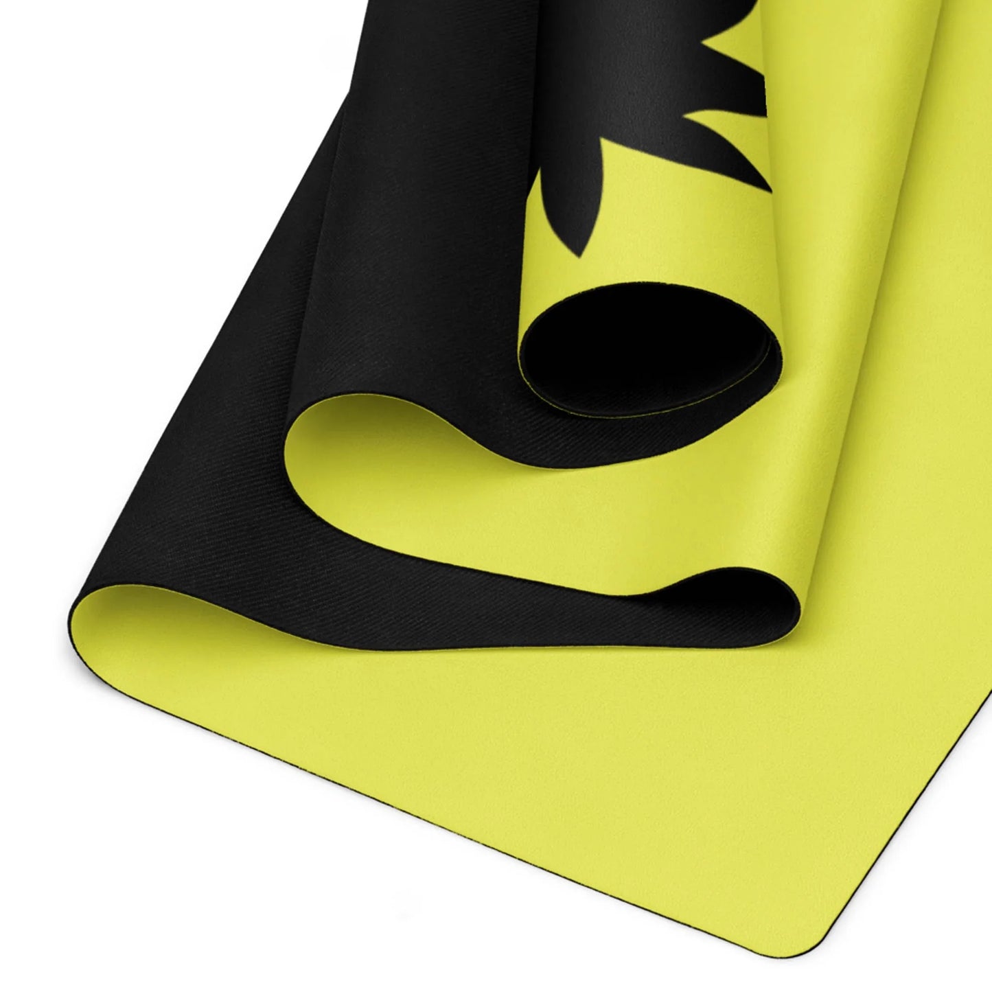 A close-up of a rolled yoga mat with a bright yellow underside and a black top layer featuring part of Mambí’s bold black graphic design.