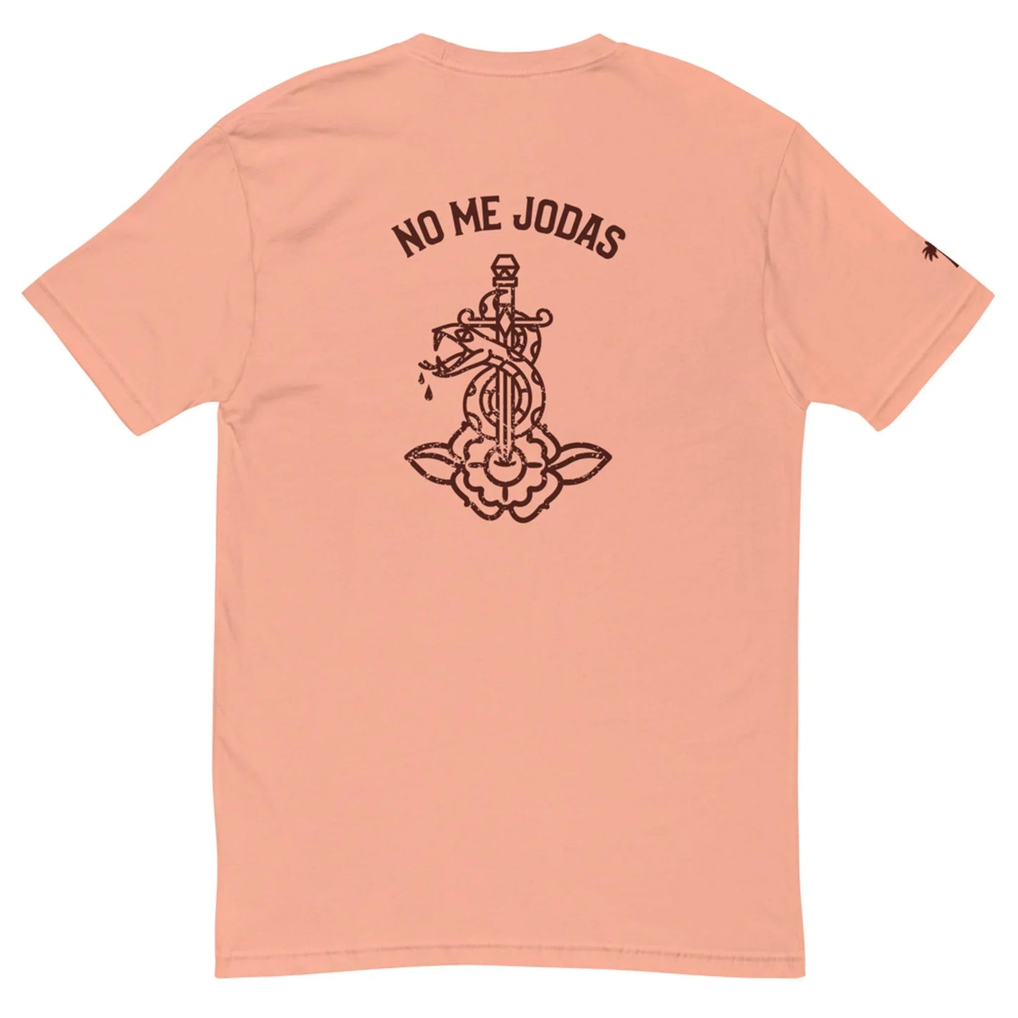 The No Me Jodas Fitted Graphic Tee by Printful features a peach hue, soft cotton fabric, and a bold black graphic of a dagger through a flower with the phrase NO ME JODAS above—perfect for fans of standout mens tees.