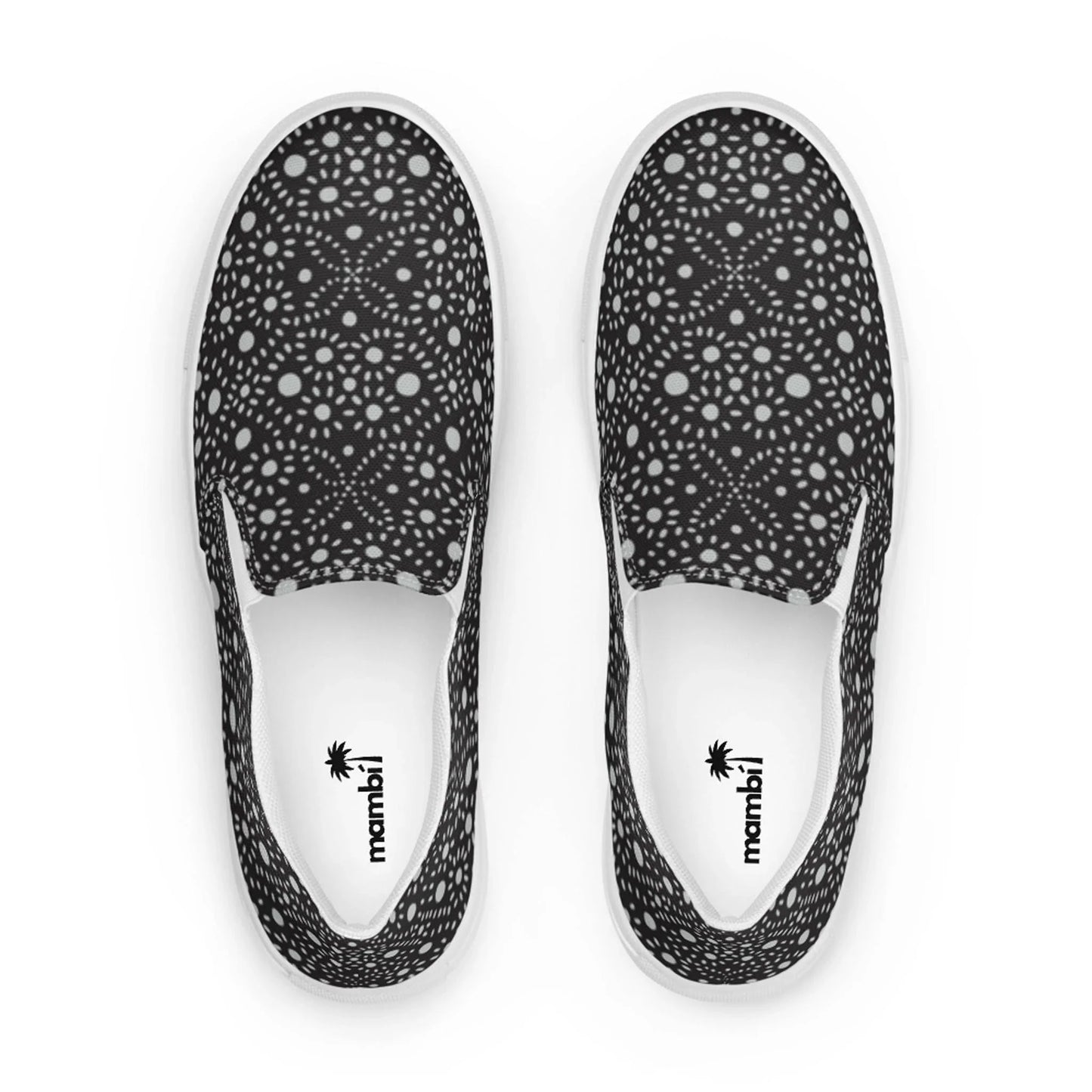 A pair of slip-on shoes with a black base and an intricate white geometric dot pattern. The insoles are white, featuring the Mambí logo and a palm tree graphic near the heel.