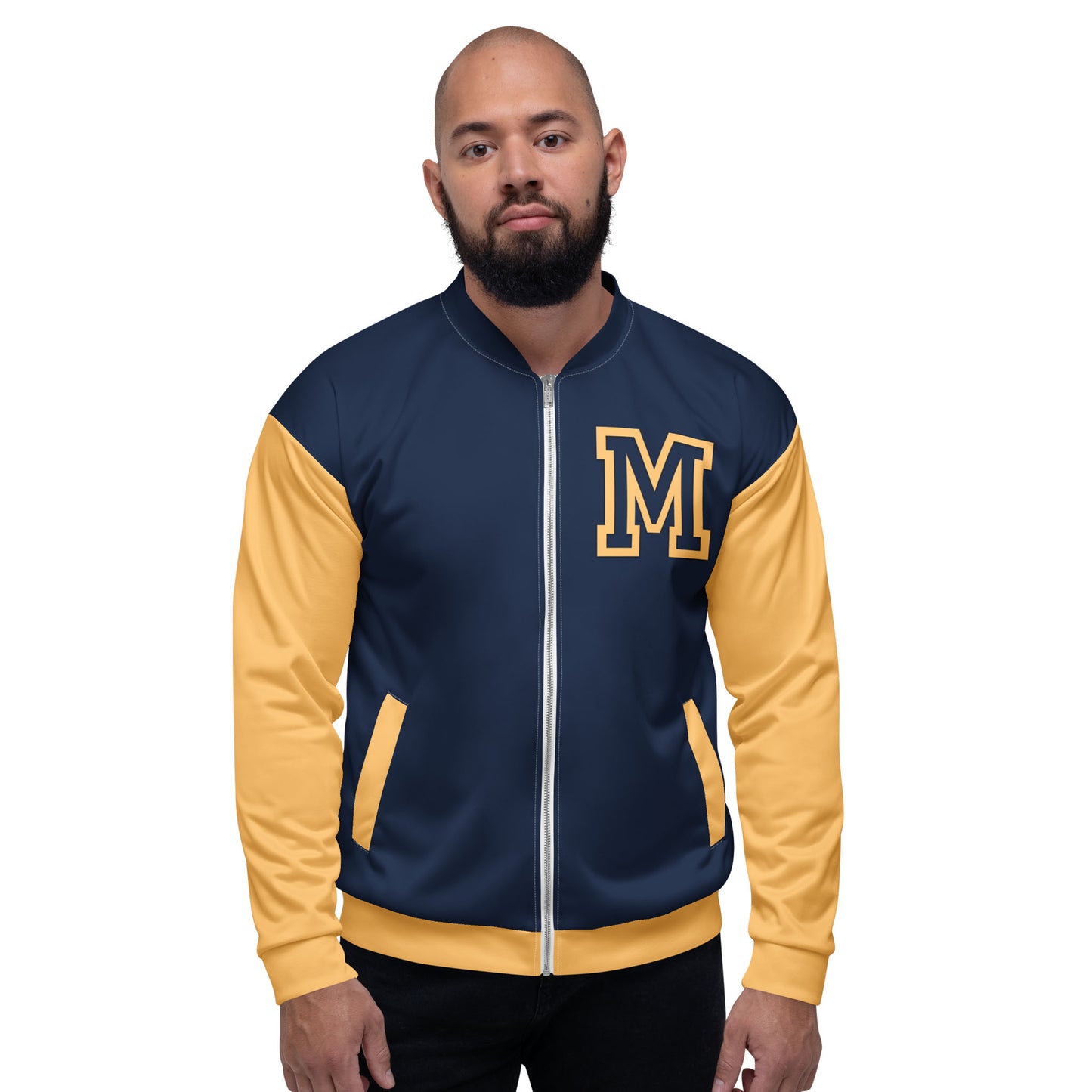 A man with a beard stands facing forward against a plain white background, wearing a navy blue and yellow letterman jacket with premium stitching and a large yellow M on the left chest.