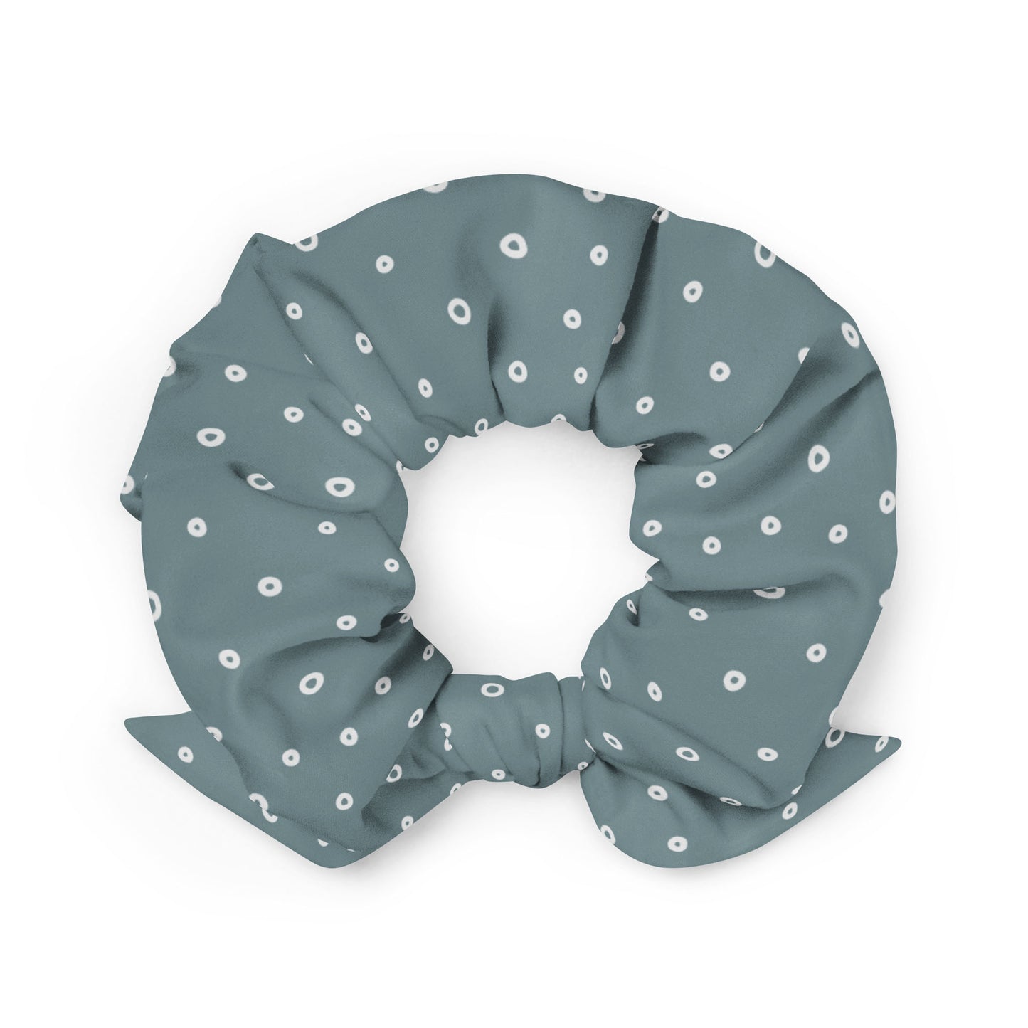 A gray-blue recycled polyester scrunchie with a bow, decorated with a pattern of small white circles evenly spaced across the fabric—a stylish and eco-friendly hair accessory.
