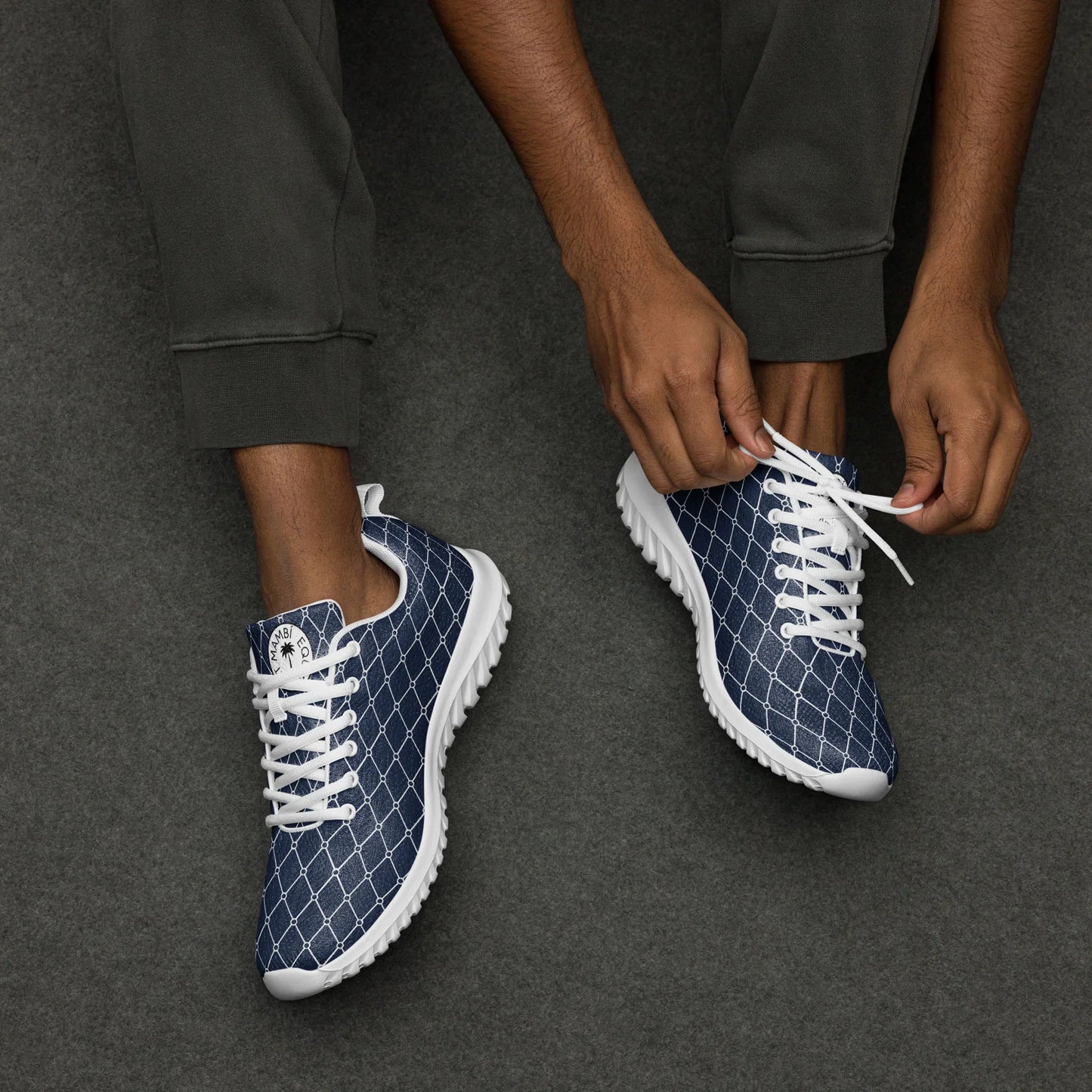 Man tying laces on navy mercury men's athletic shoes with white geometric pattern